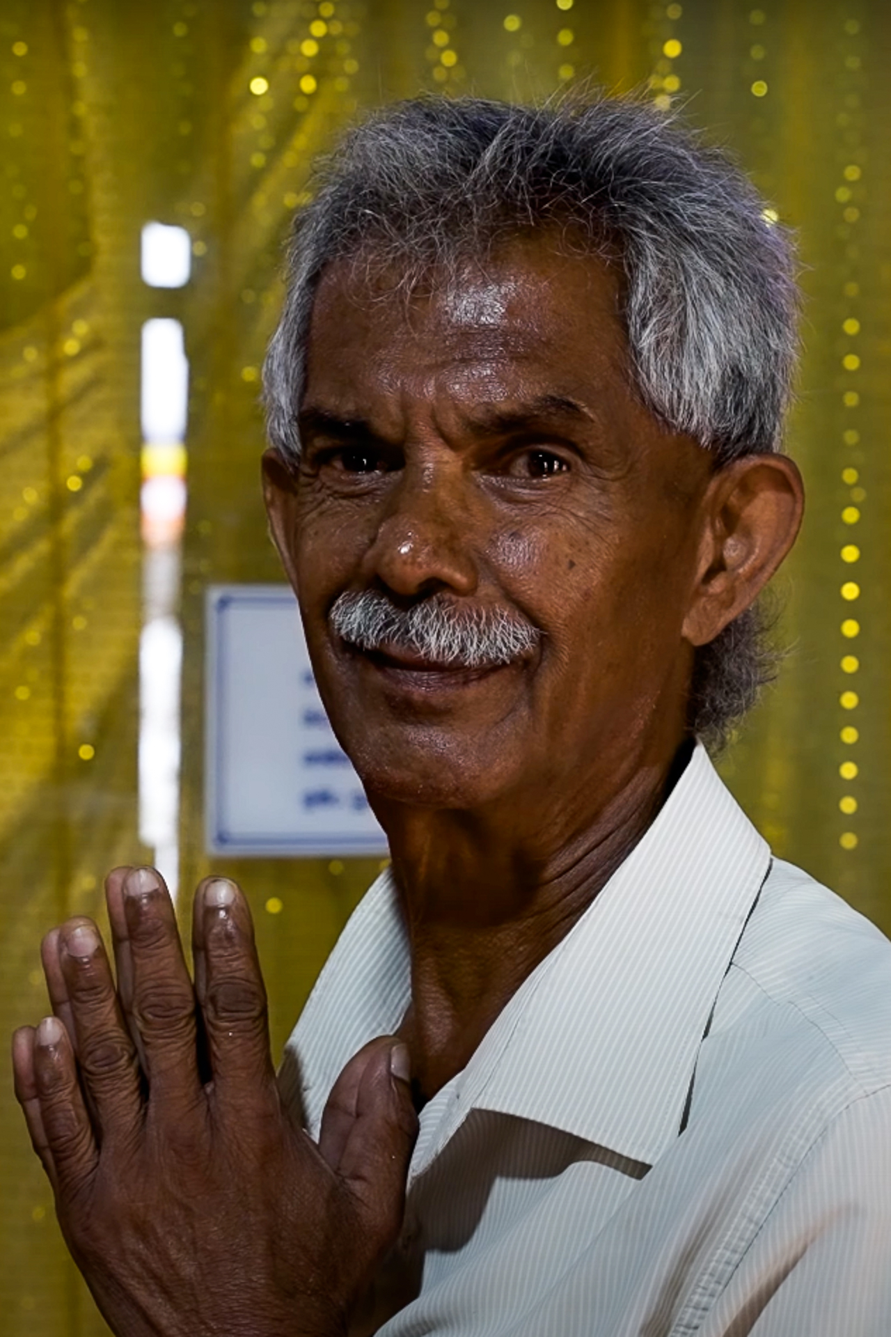 A local man praying in front of a Buddha statue at the temple of the Sacred Tooth Relic in Kandy.