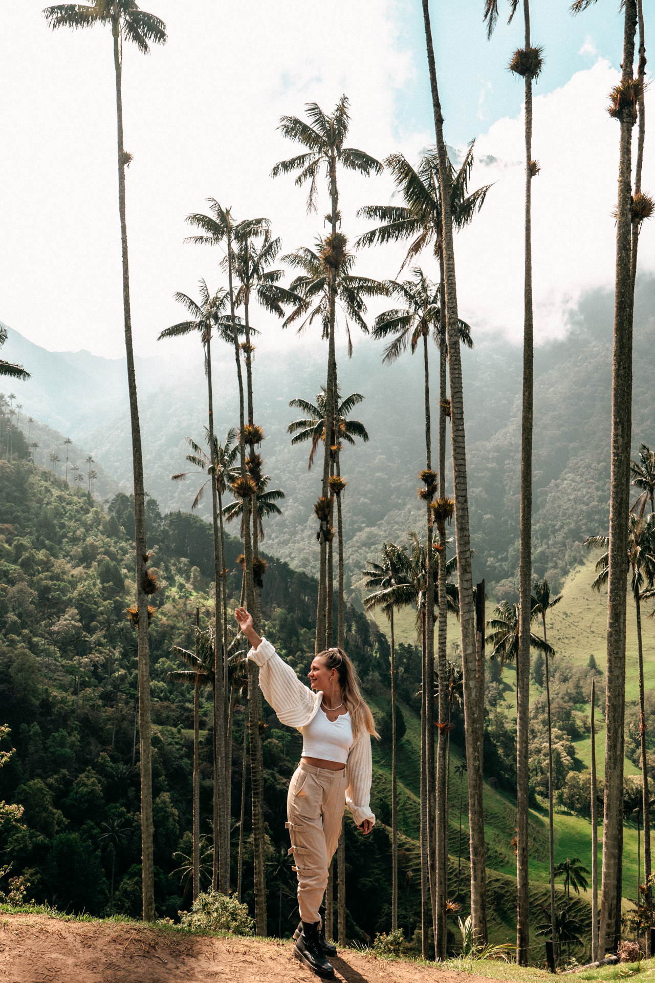 Traveler posing among the towering wax palm trees in the Cocora Valley, Colombia.