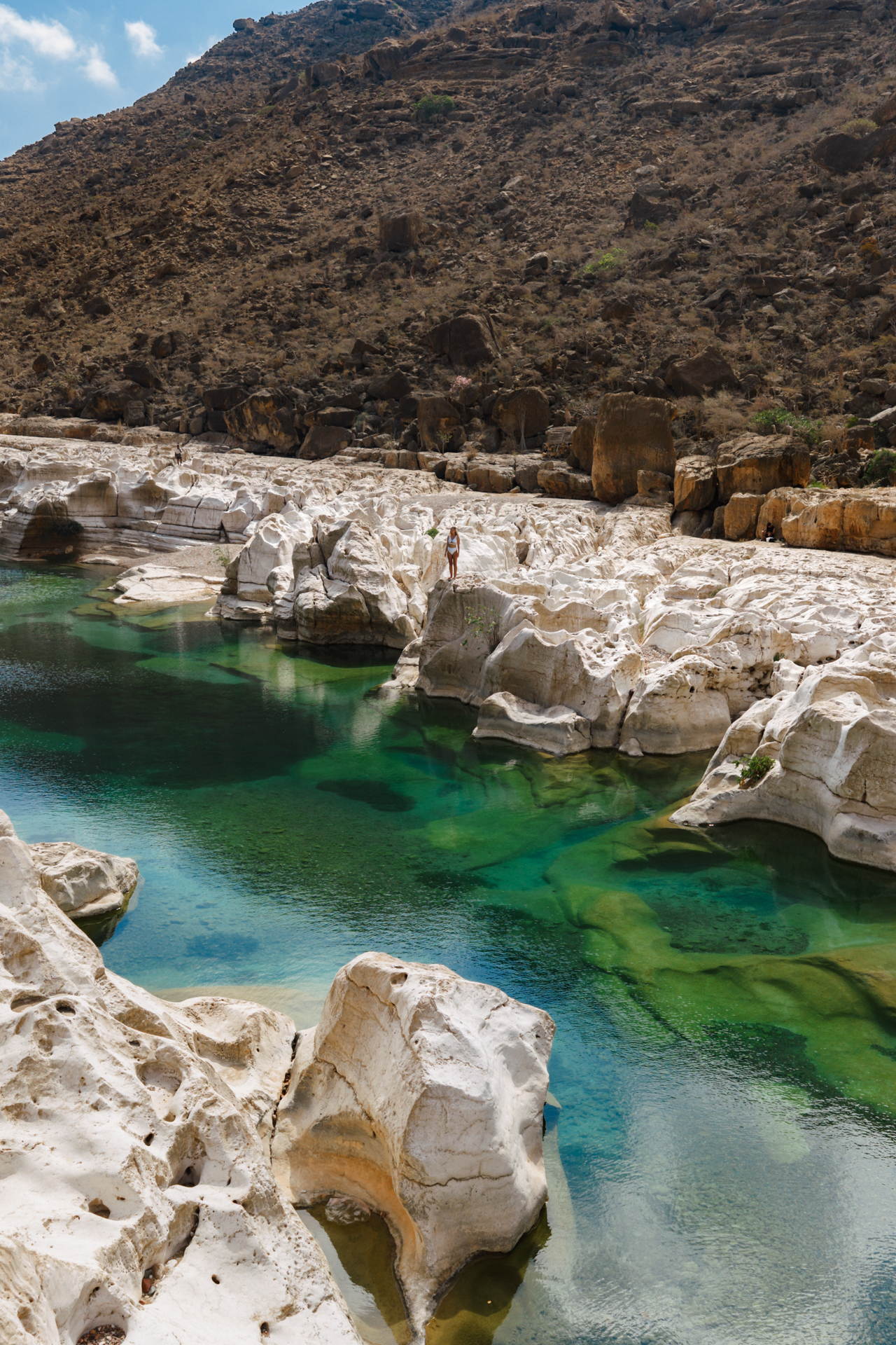 Wadi Kalissan a Crystal-clear green pool among white rocks and mountains in Socotra’s rugged landscape.