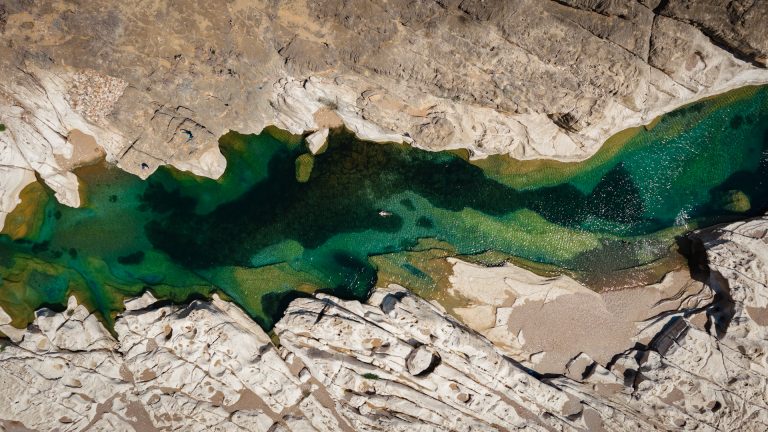 Woman lying in Wadi Kalissan in the turquoise water on Socotra.