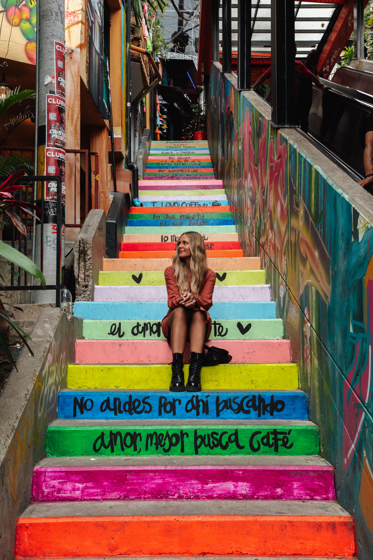 Woman sitting on colorful stairs in Medellin, Colombia.
