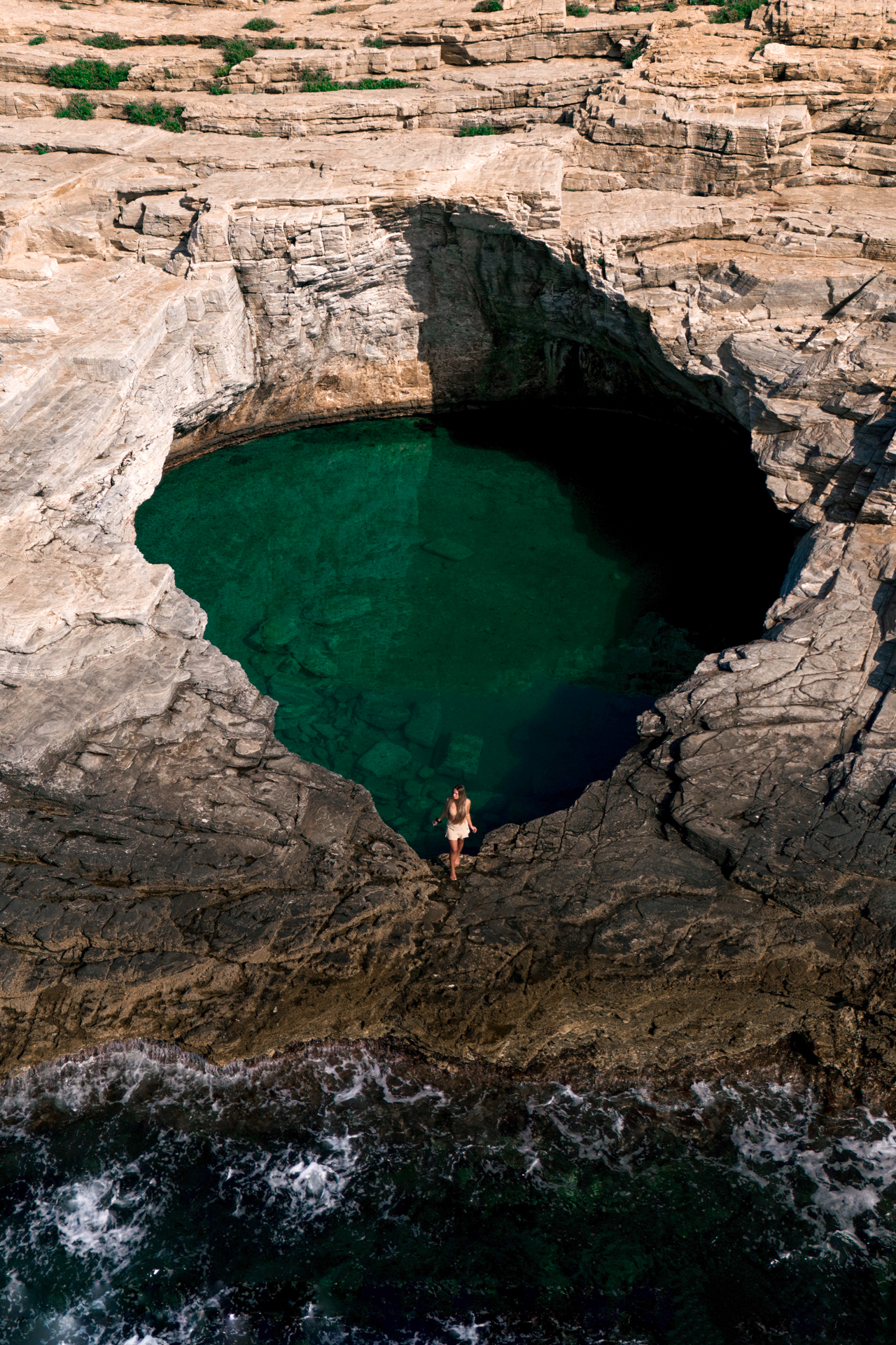 Woman standing by the natural rock pool of Giola Lagoon on the island of Thassos, Greece.