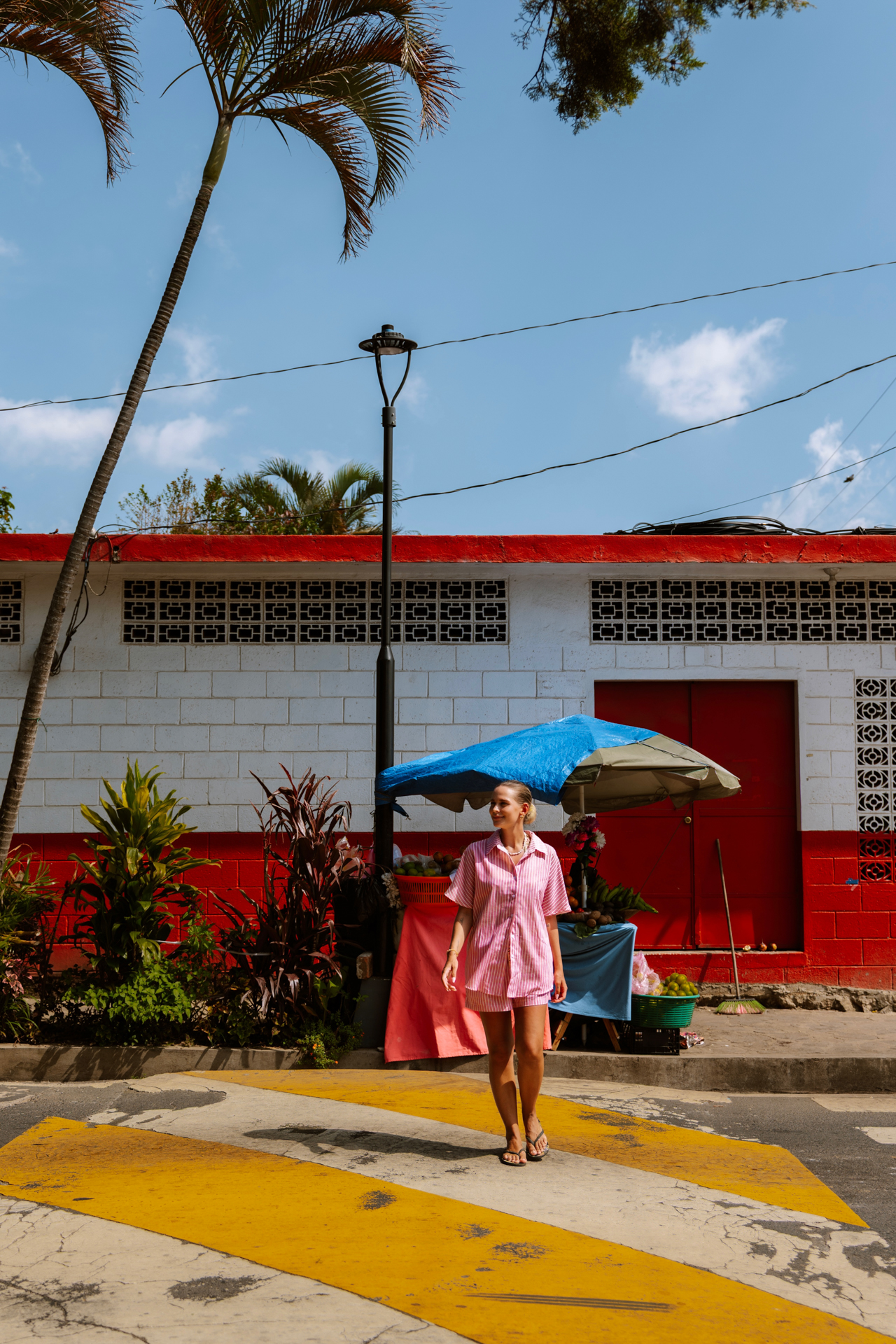 Ruta de la Flores Traveler walking along Ruta de las Flores, surrounded by colorful walls and local market stalls.