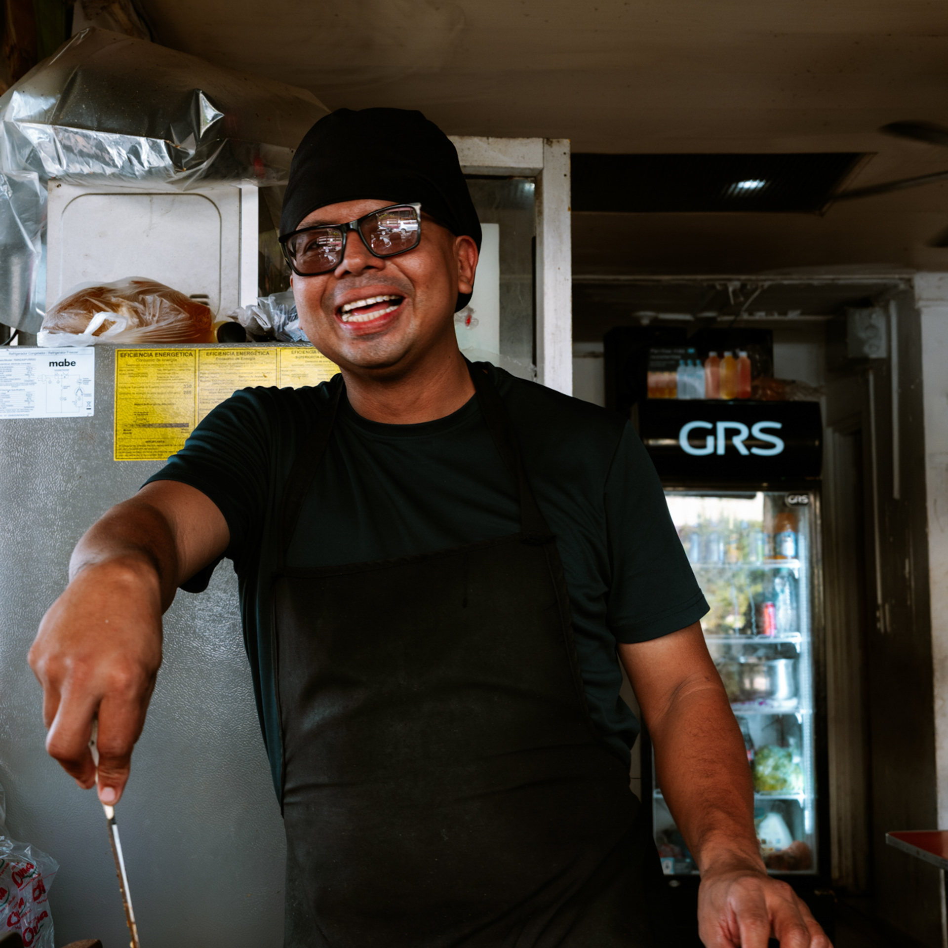 Culture in El Salvador Street food vendor cooking and smiling at his stand in El Salvador.