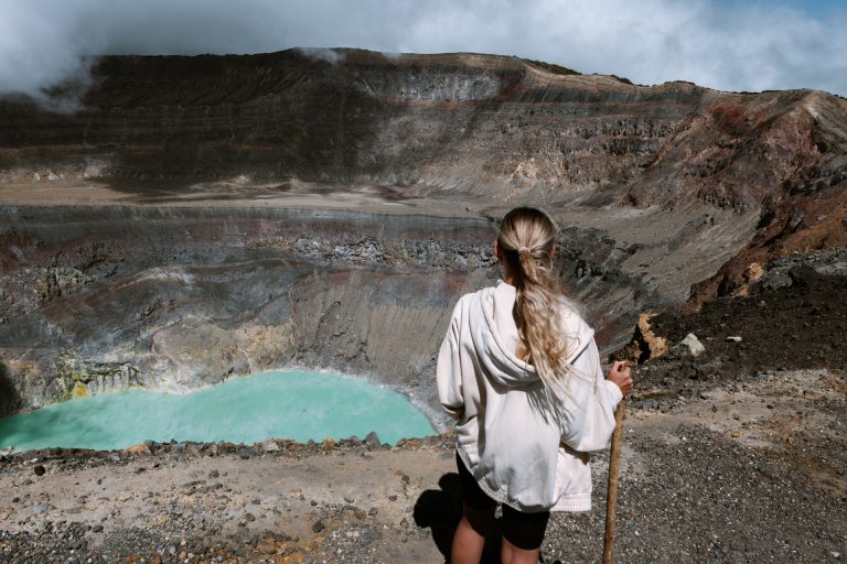 Traveler overlooking the turquoise crater lake of Santa Ana Volcano in El Salvador.
