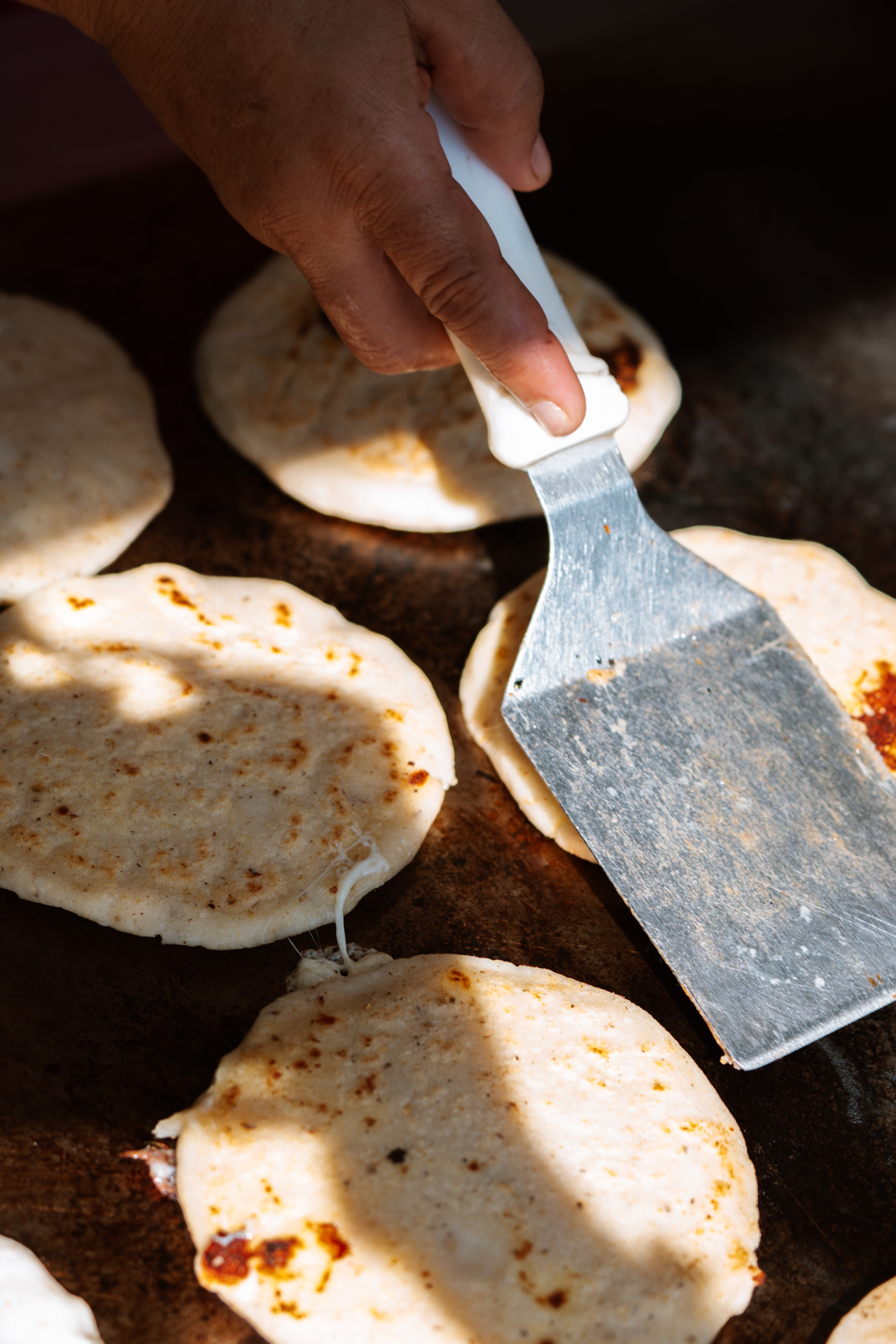 Food in El Salvador Traditional Salvadoran pupusas being cooked on a hot griddle.