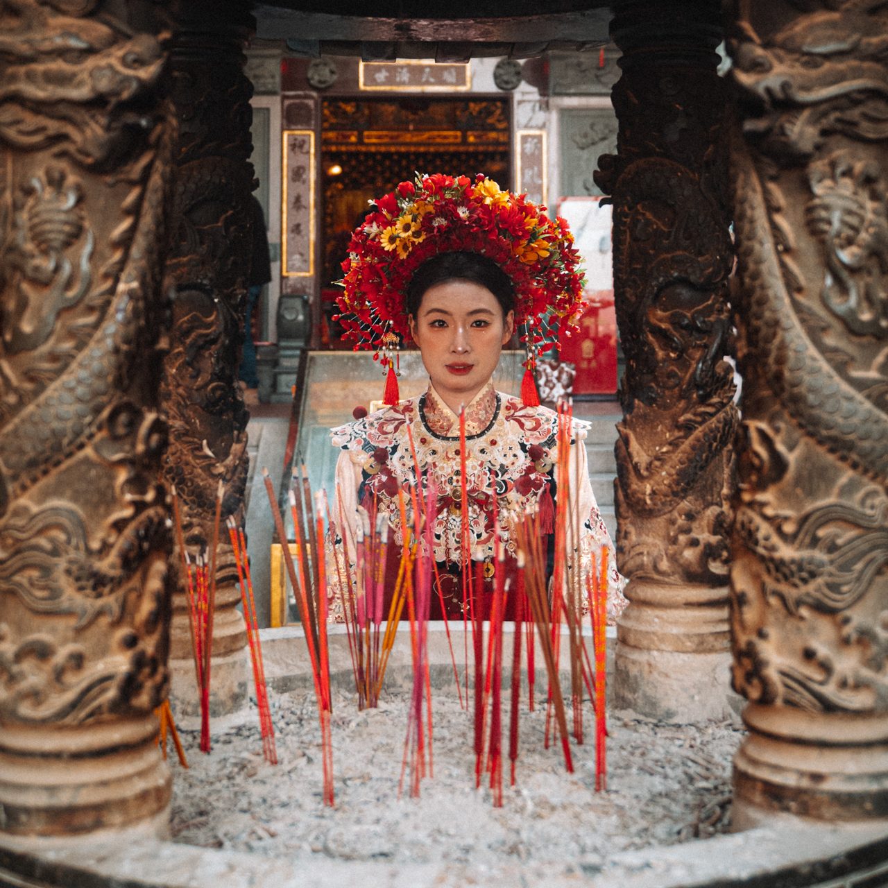Traditions in China Woman in traditional Chinese ceremonial attire standing behind a large incense burner in a temple in Fujian, China