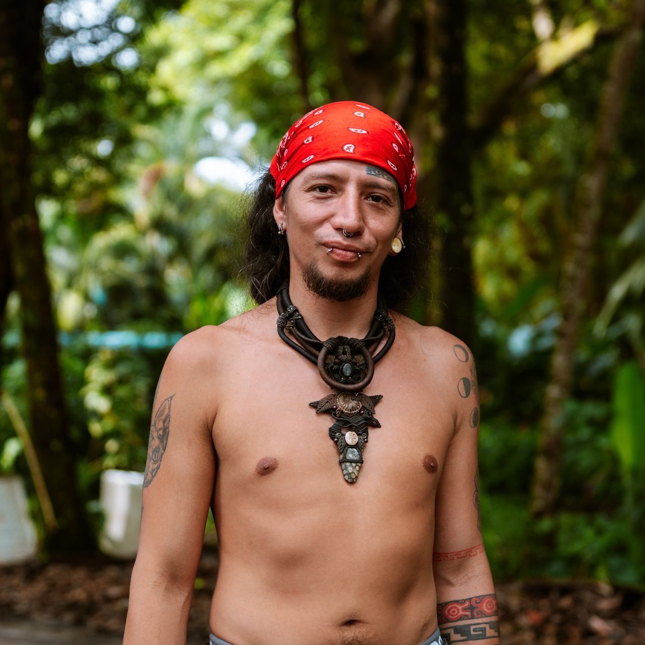 Portrait of a man with red bandana and tribal necklace in tropical Costa Rica forest