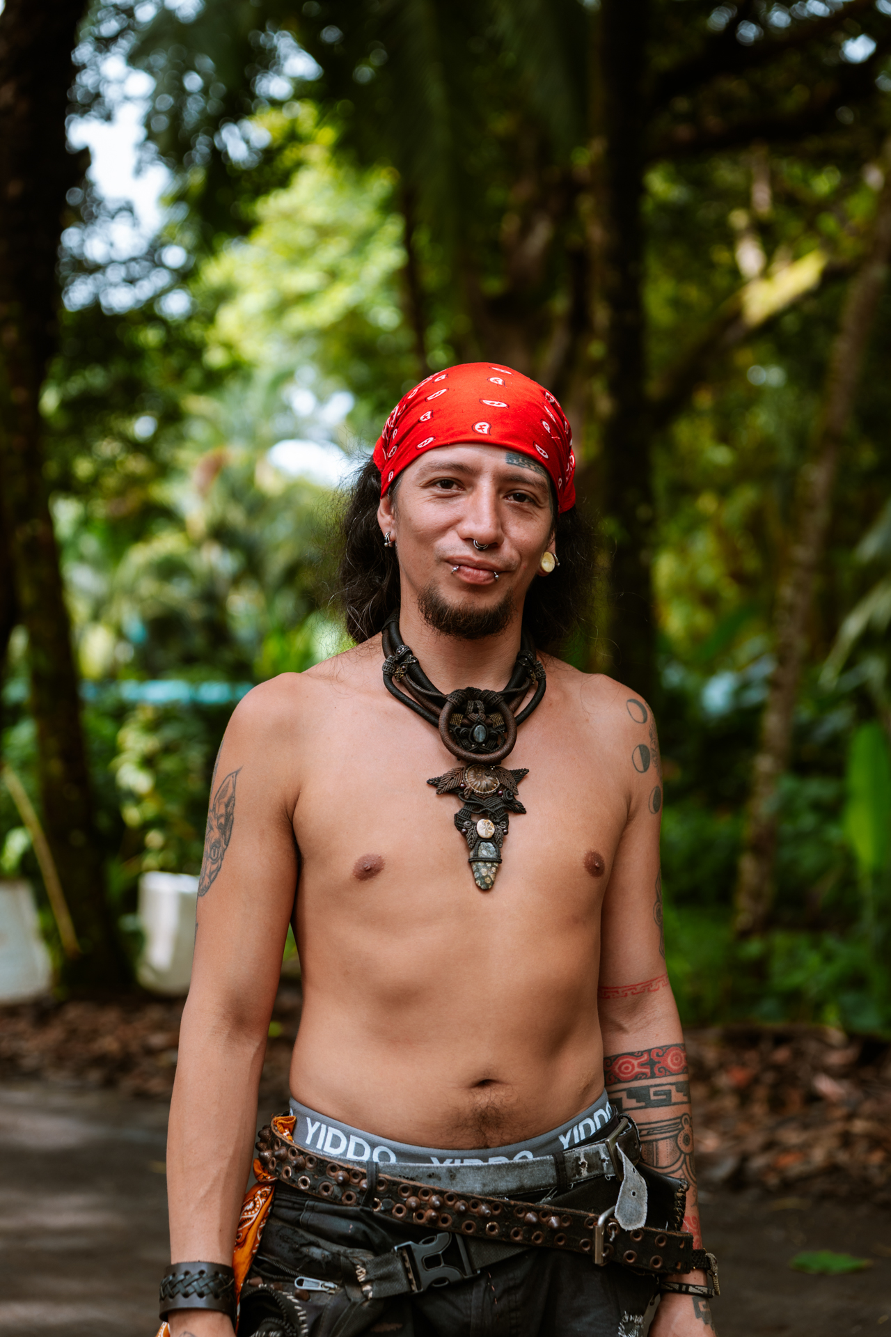 Portrait of a man with red bandana and tribal necklace in tropical Costa Rica forest