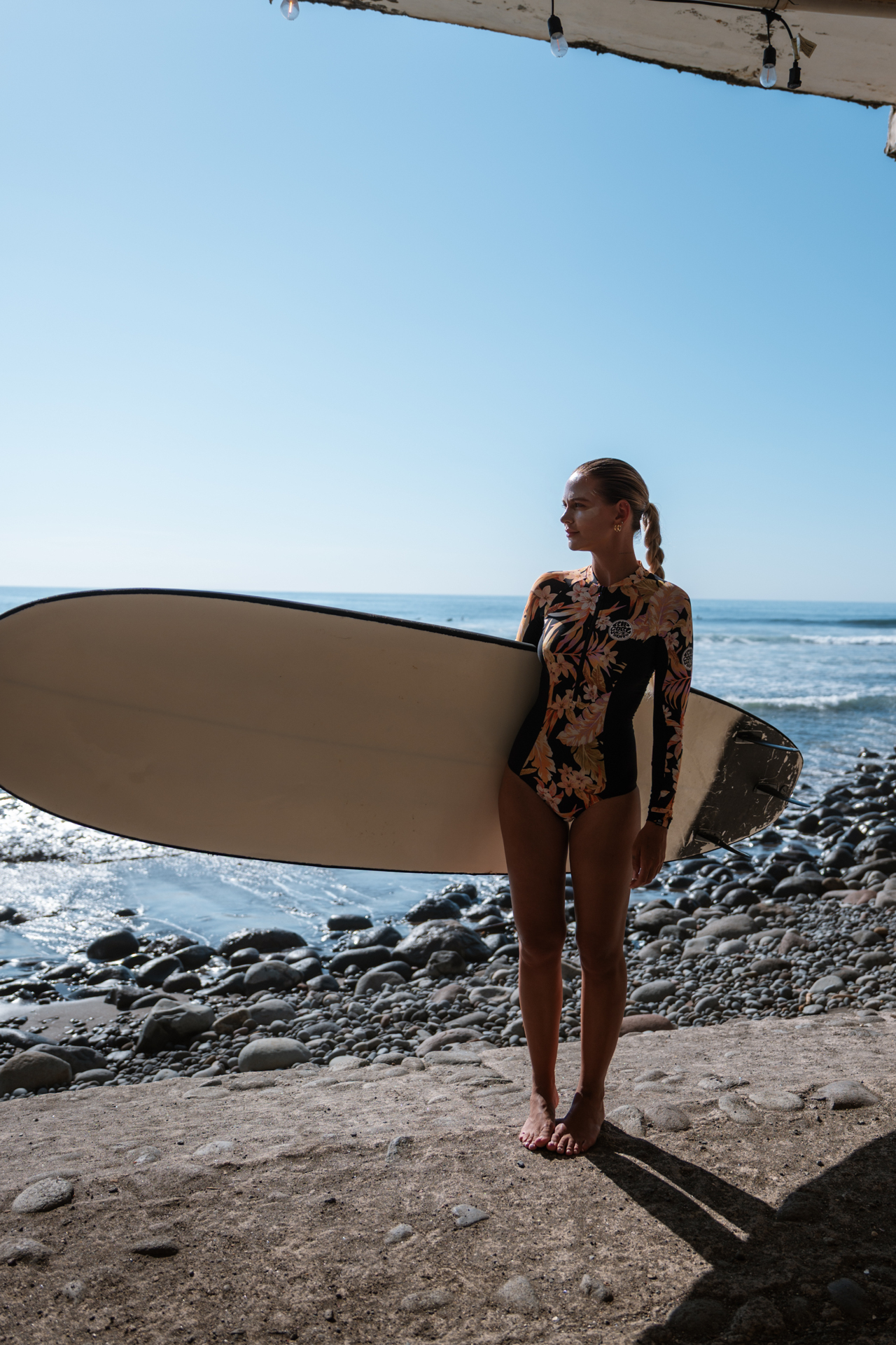 Woman with surfboard at El Zonte Beach, El Salvador