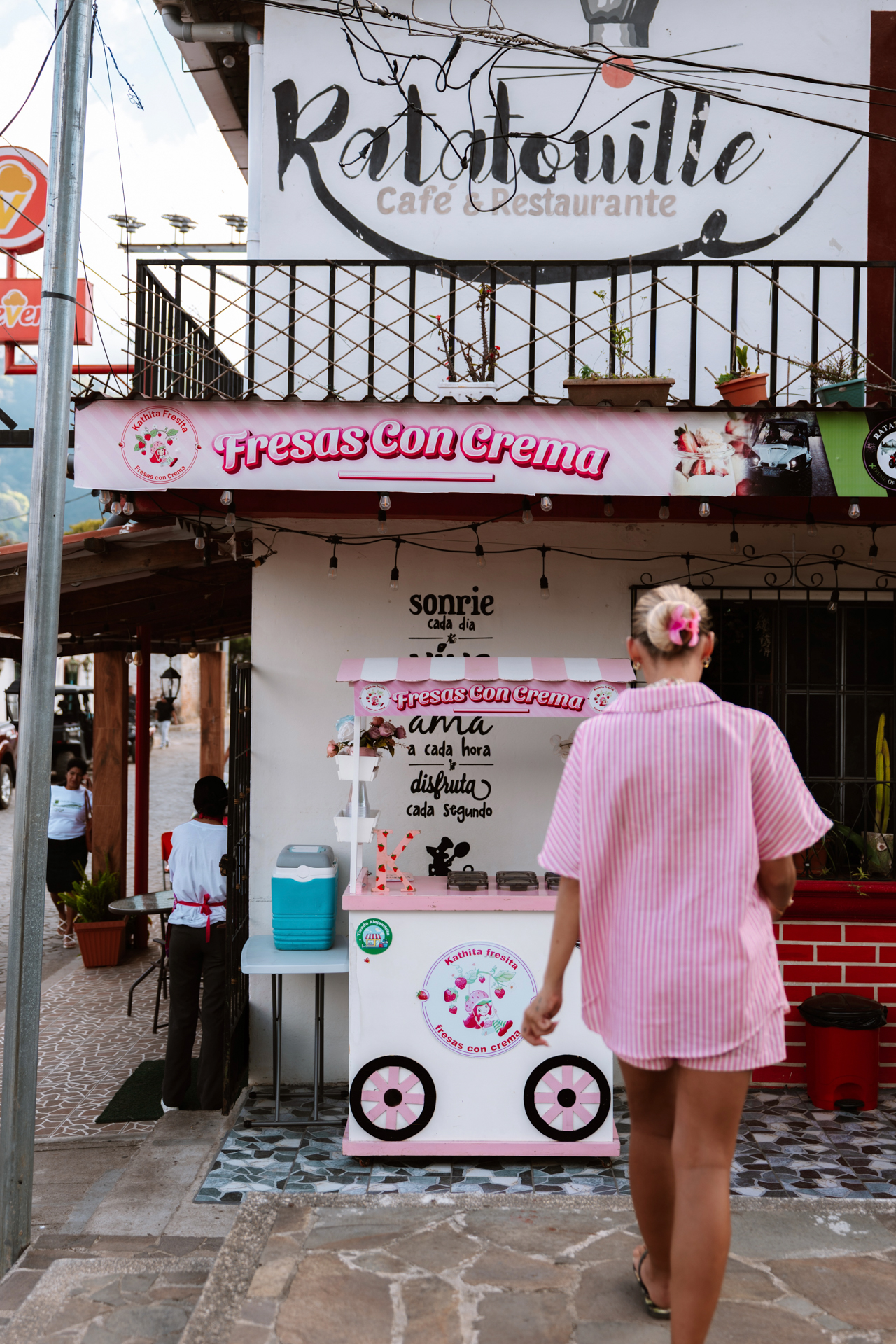 Pink Fresas con Crema stand on Ruta de las Flores with woman walking by
