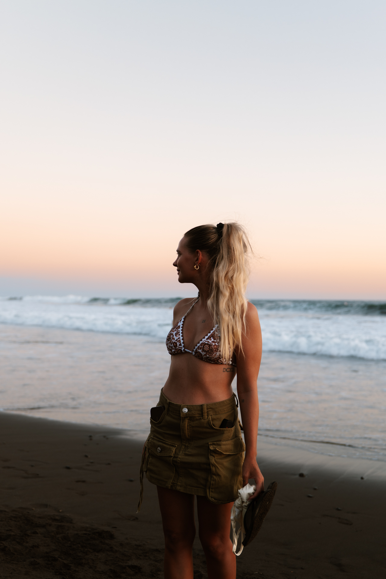 Woman enjoying sunset at El Tunco Beach, El Salvador