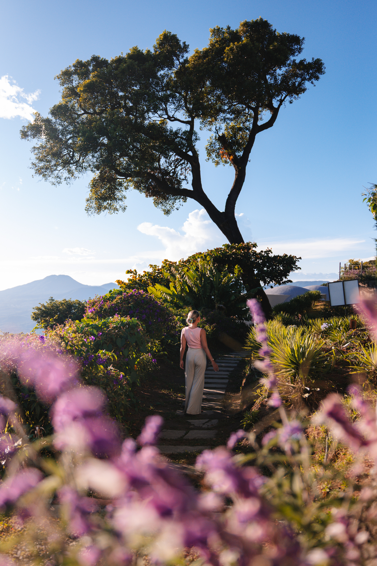 Woman walking through scenic garden with mountain views in Cerro Verde, El Salvador