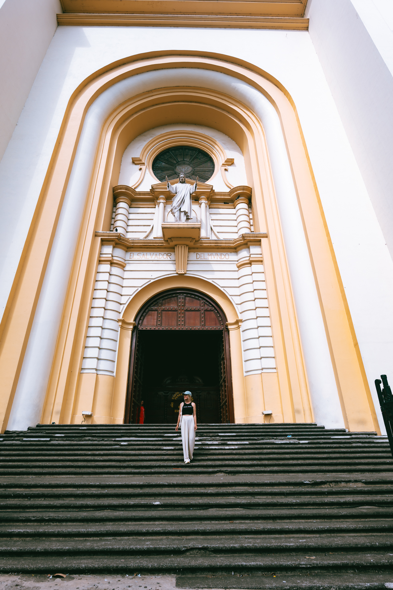 Woman walking down cathedral steps in San Salvador, El Salvador
