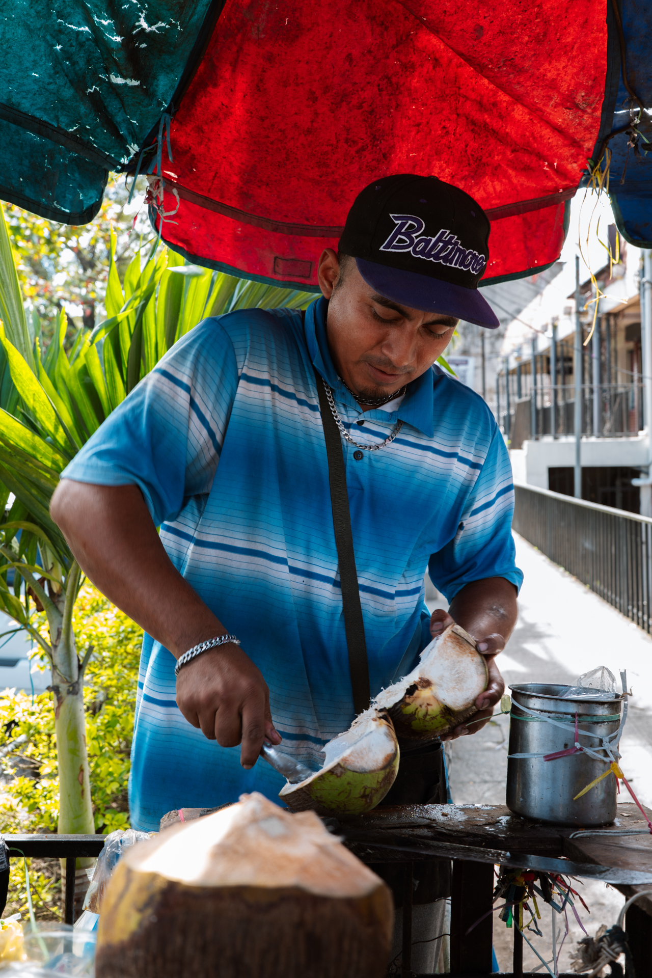 Street vendor preparing fresh coconut drink in San Salvador, El Salvador