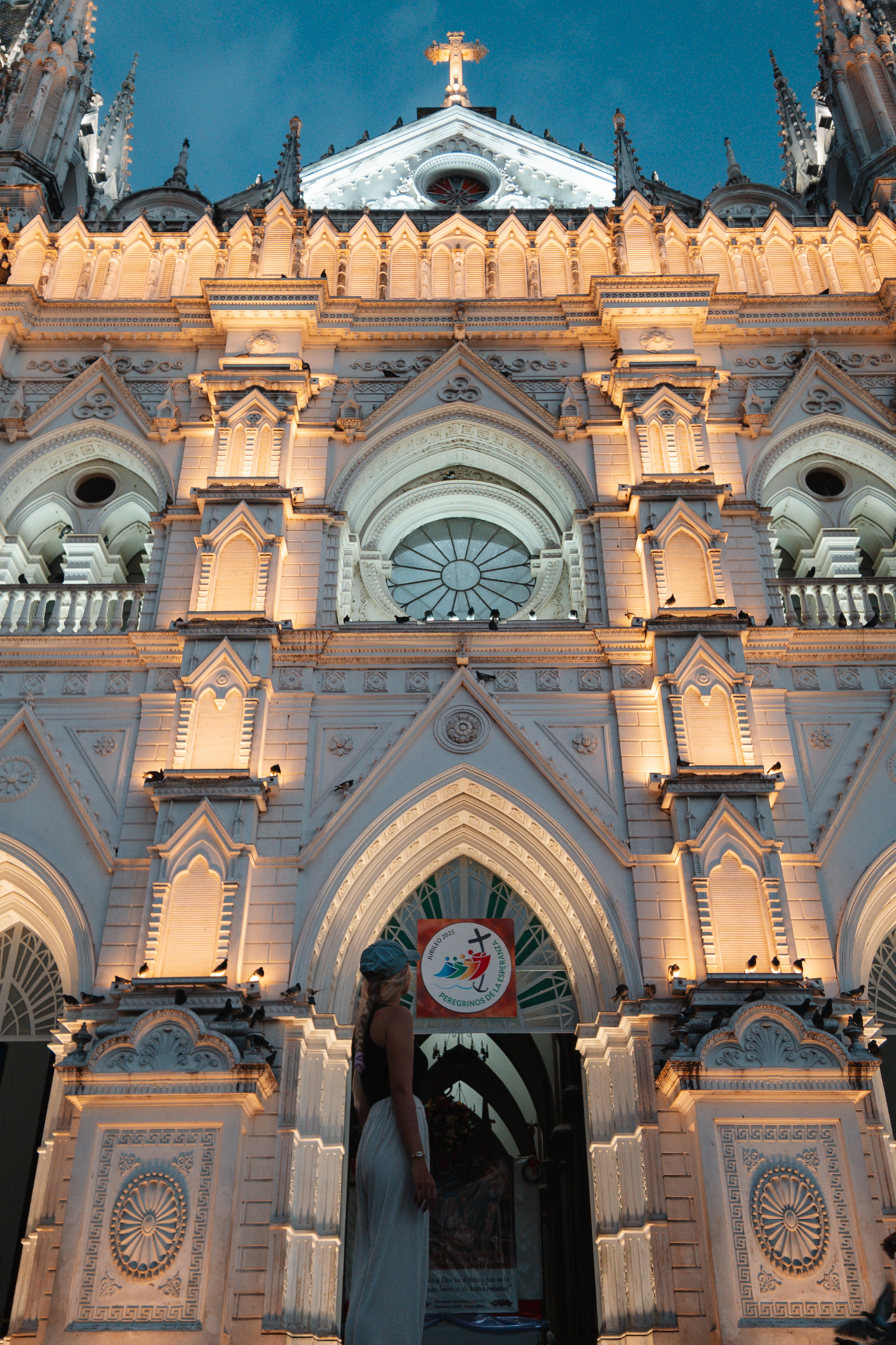 Traveler admiring illuminated Santa Ana Cathedral at dusk in El Salvador