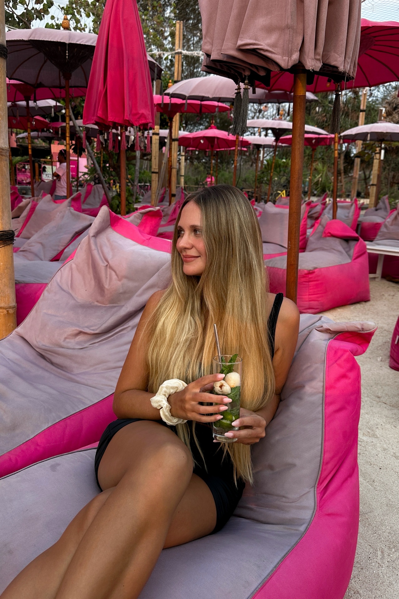 Pinkcoco Beach Club in Gili Trawangan with a woman drinking a cocktail