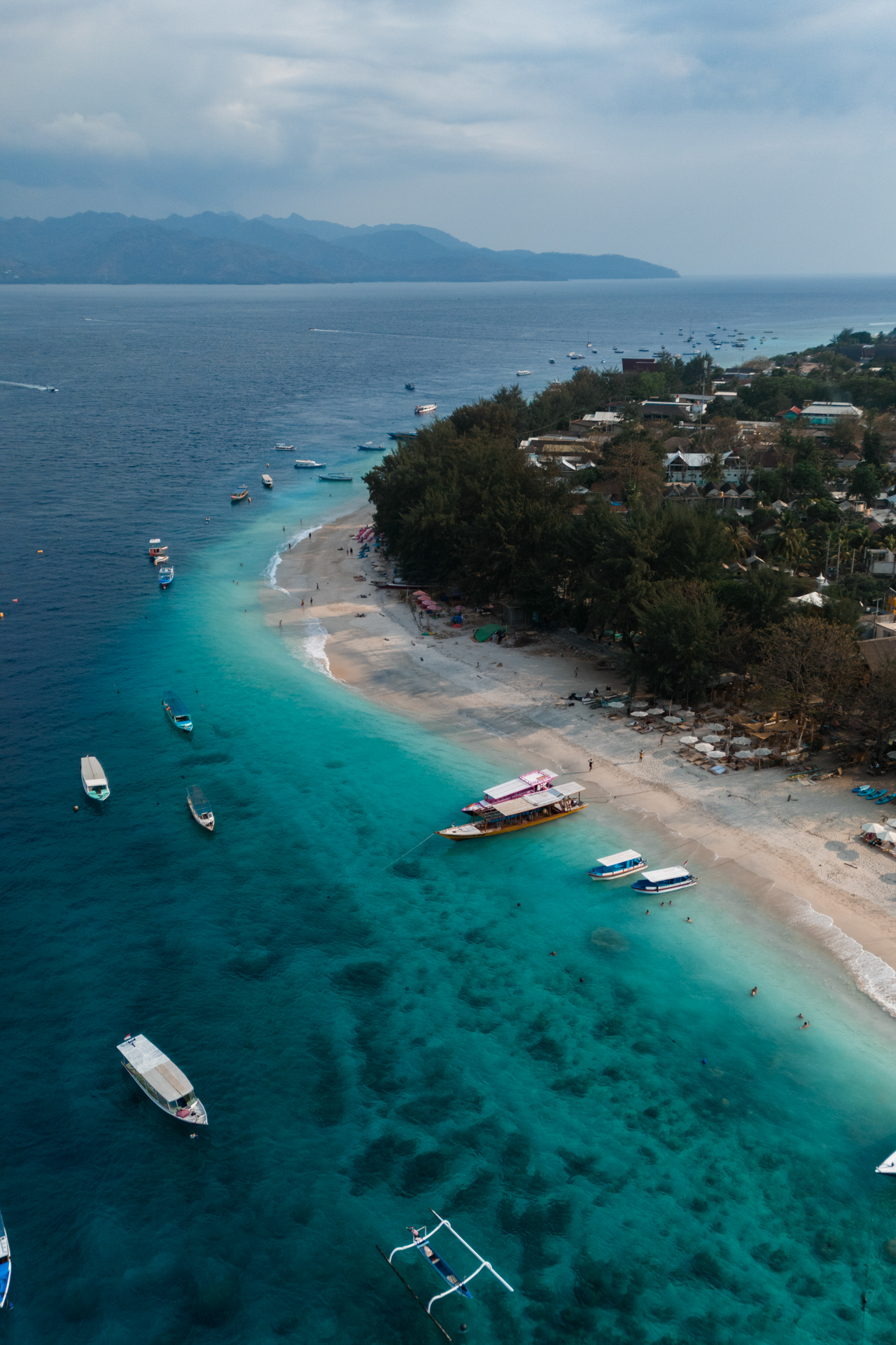 Aerial view of Gili Trawangan shoreline with turquoise sea and boats