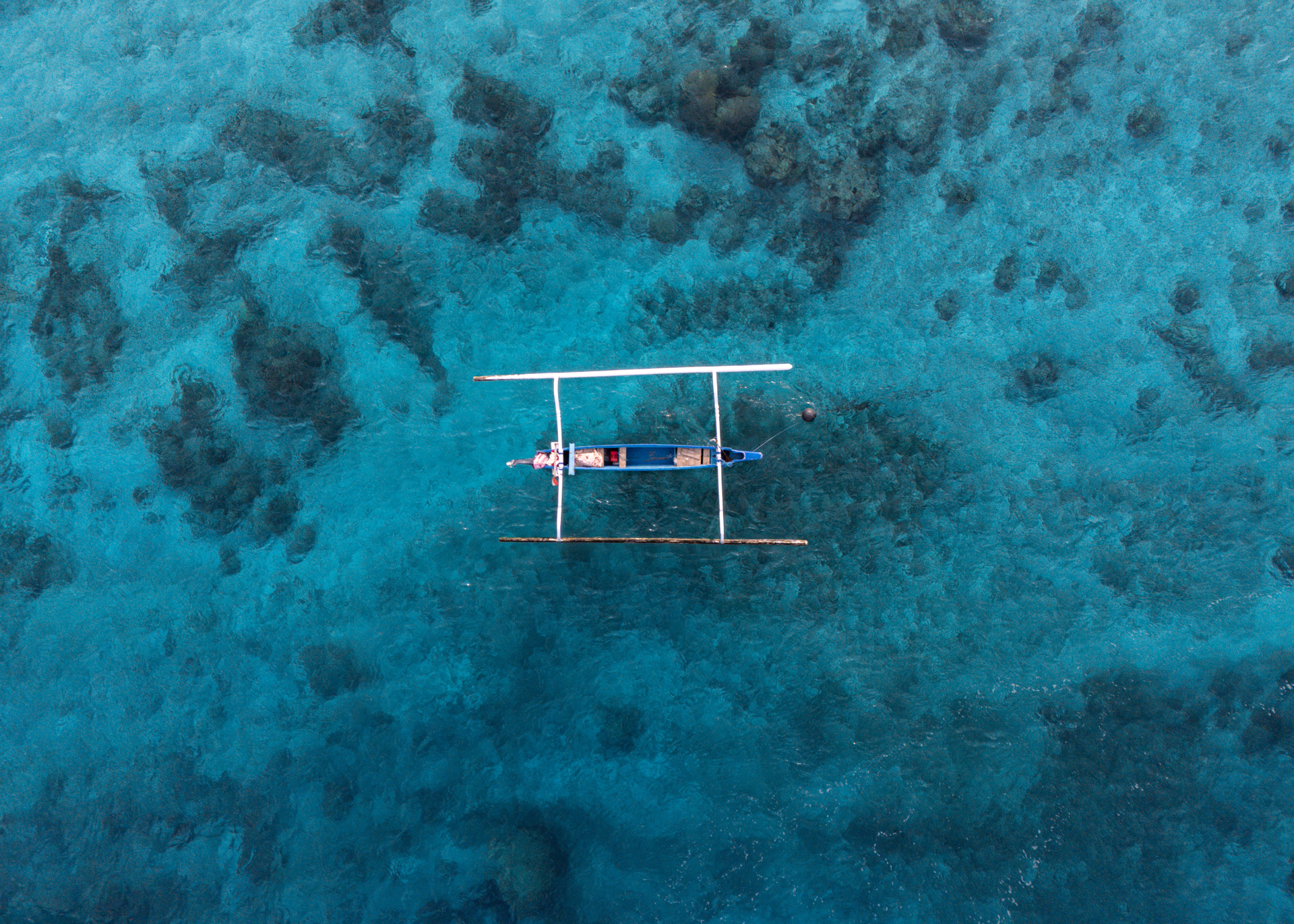 Traditional outrigger boat over turquoise water in the Gili Islands, Lombok