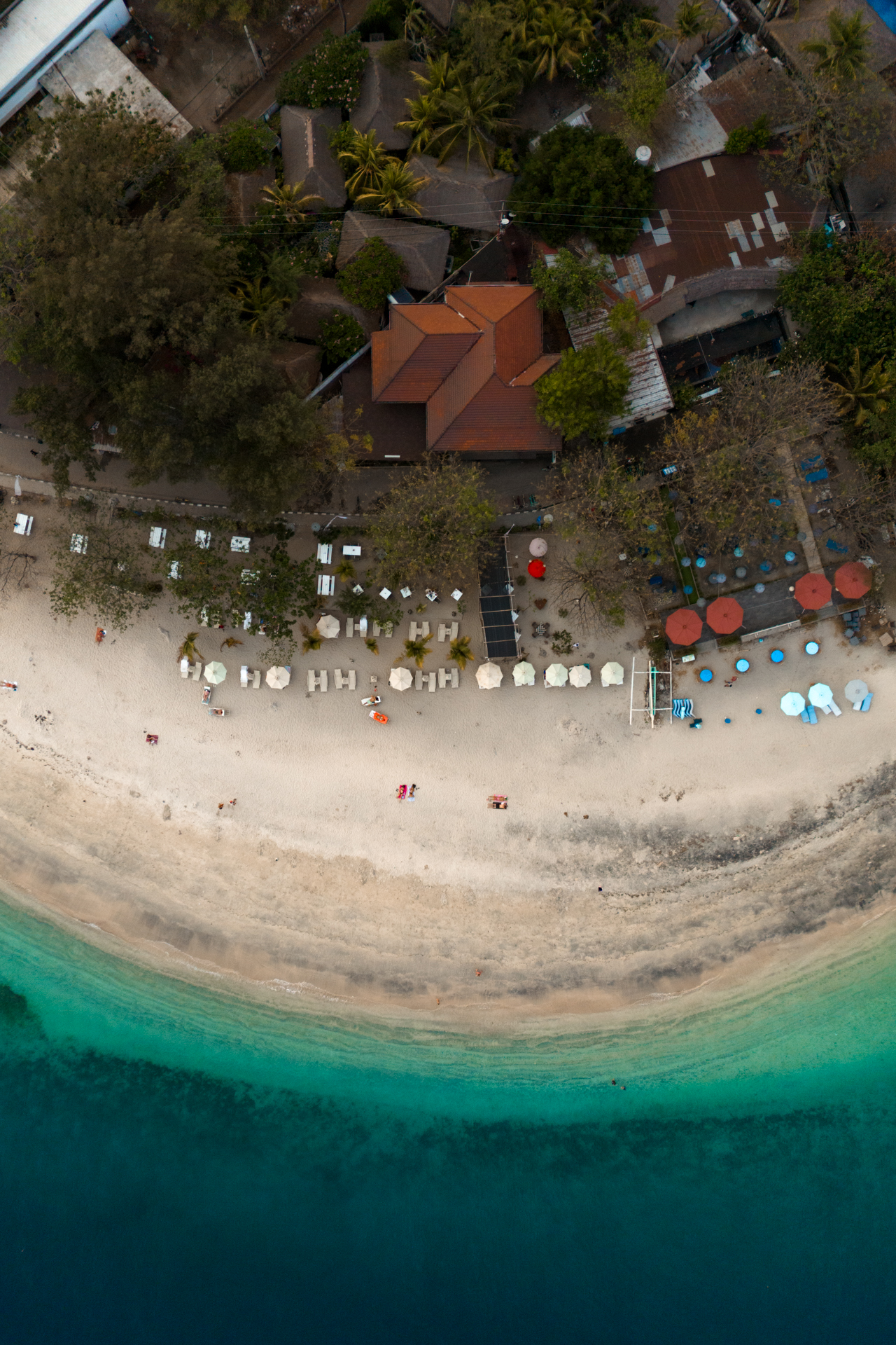 Aerial view of Gili Air beachfront with turquoise water and beach lounges