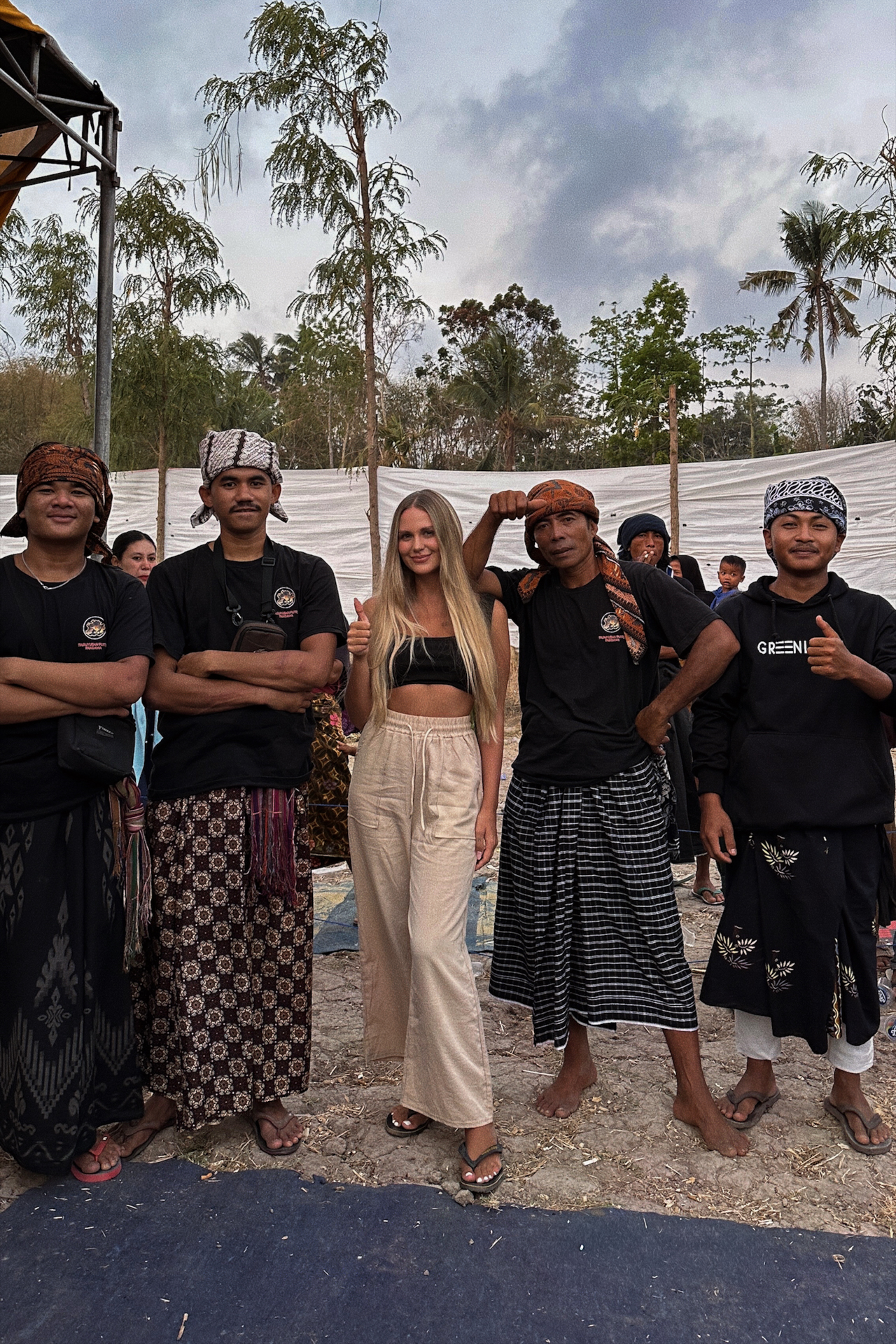 Traveler posing with Sasak men after stick fighting ceremony in Lombok
