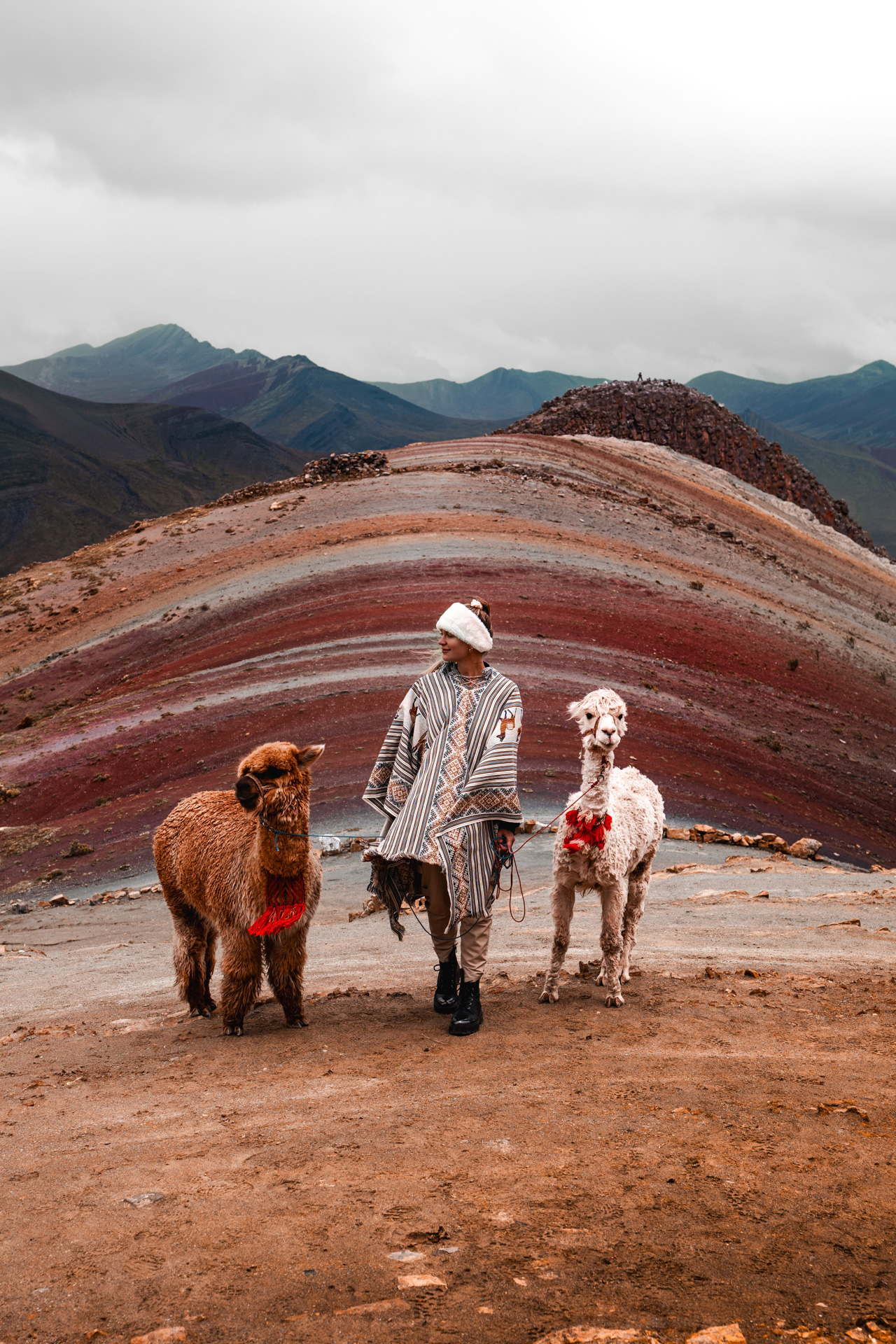 Woman with alpacas standing at Rainbow Mountain Palccoyo in Peru