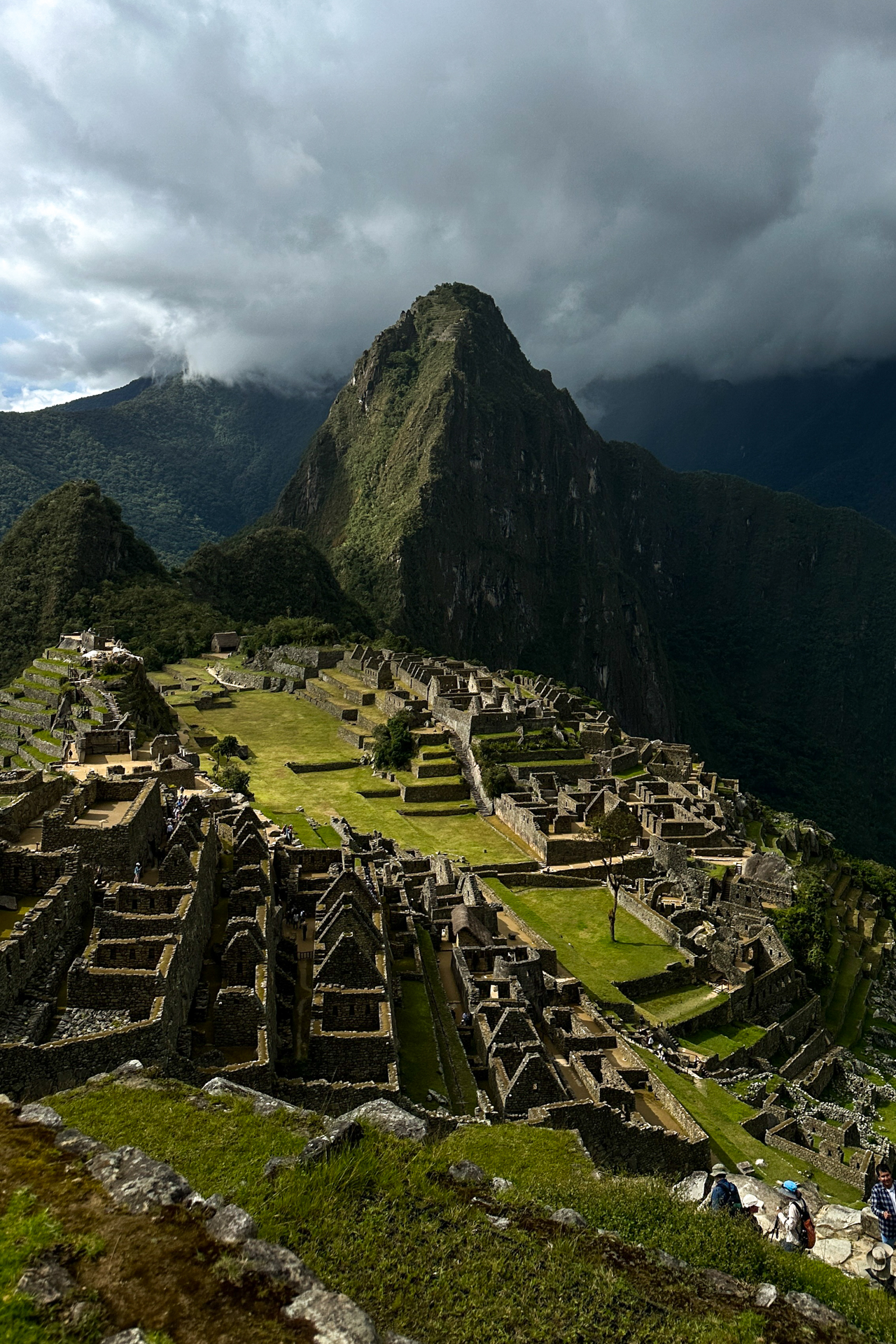 Panoramic view of Machu Picchu ruins with Huayna Picchu mountain and dramatic clouds