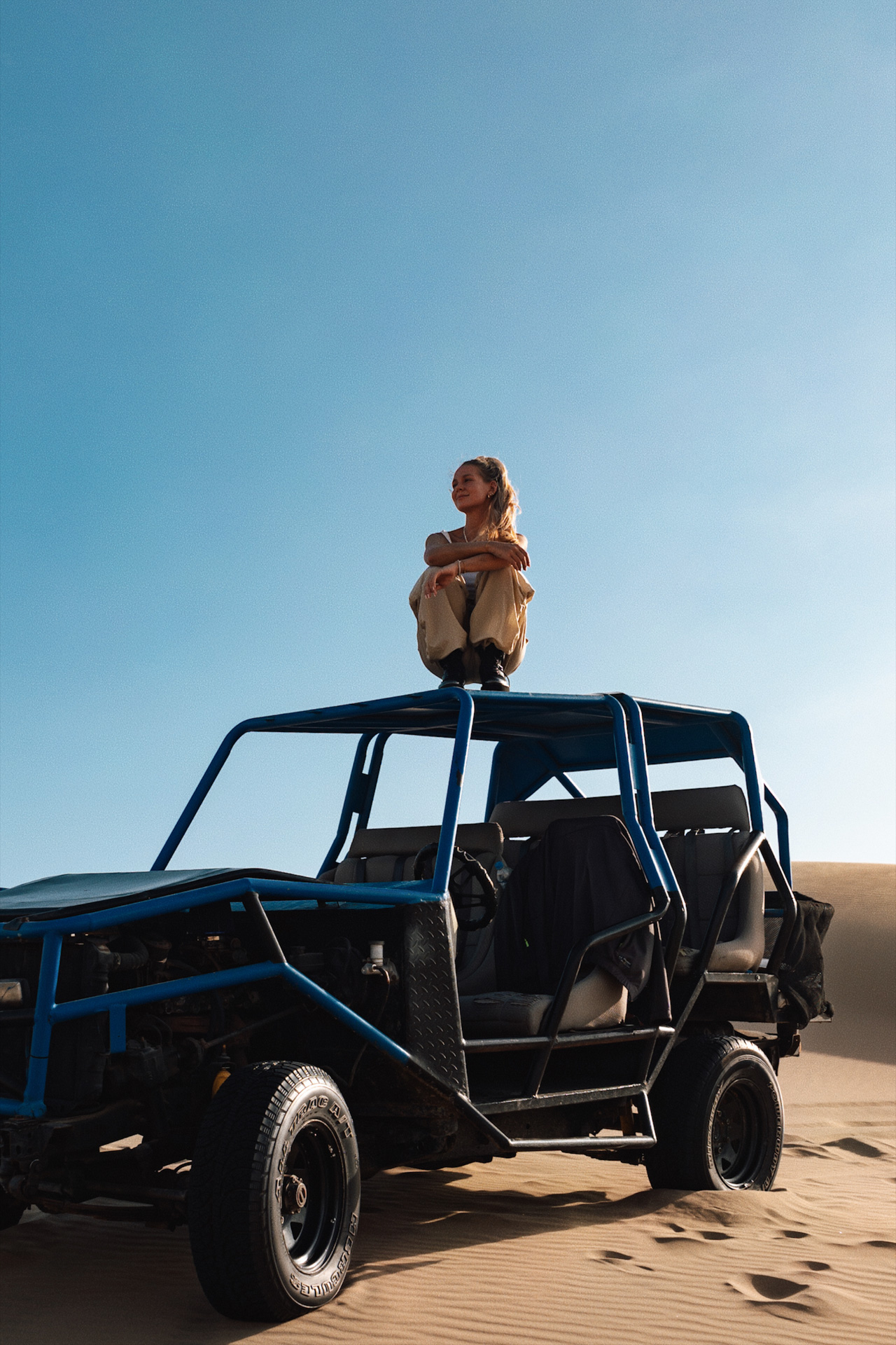 Traveler sitting on a dune buggy during a desert adventure in Huacachina, Peru