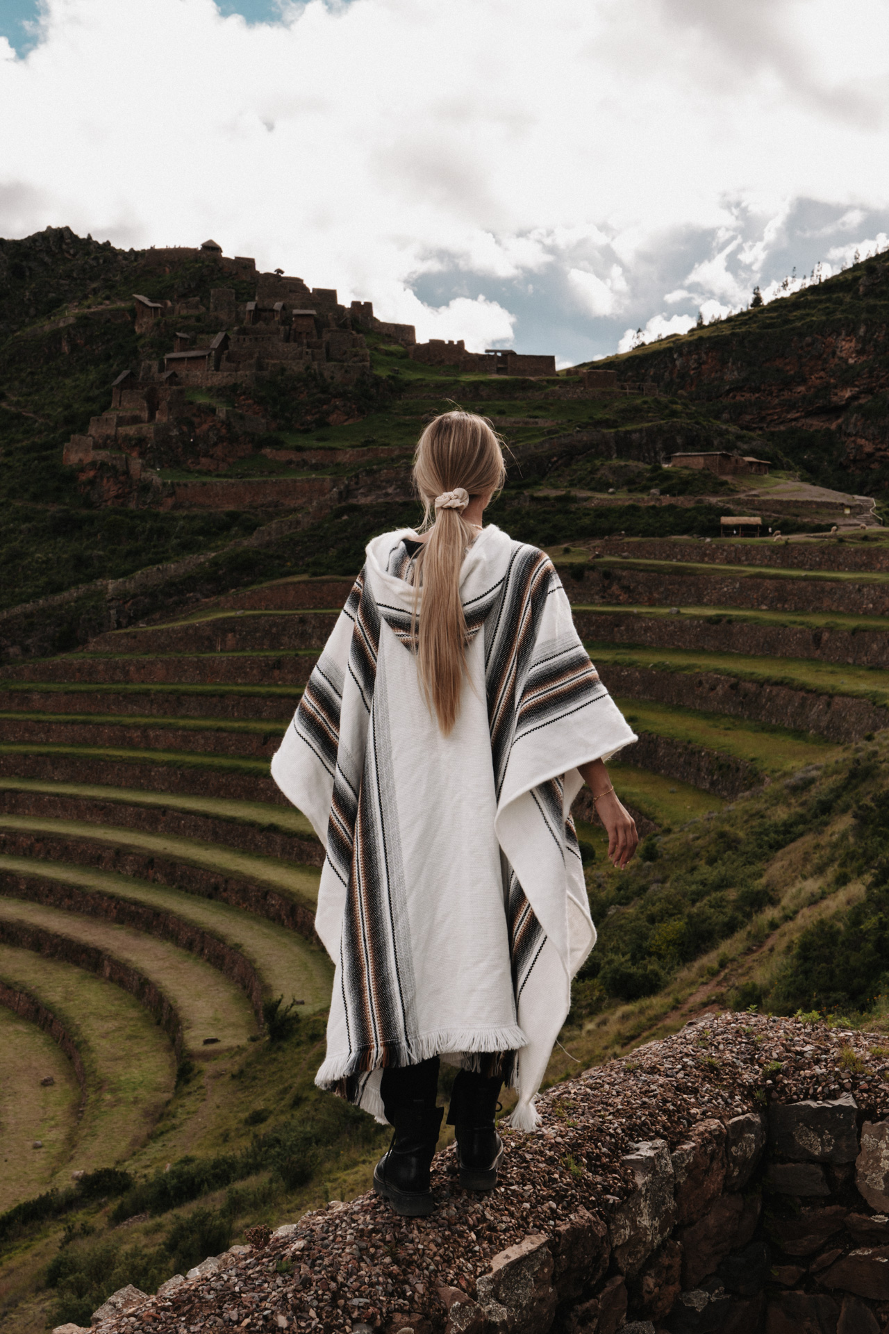 Traveler overlooking the terraced ruins of Pisac in the Sacred Valley, Peru