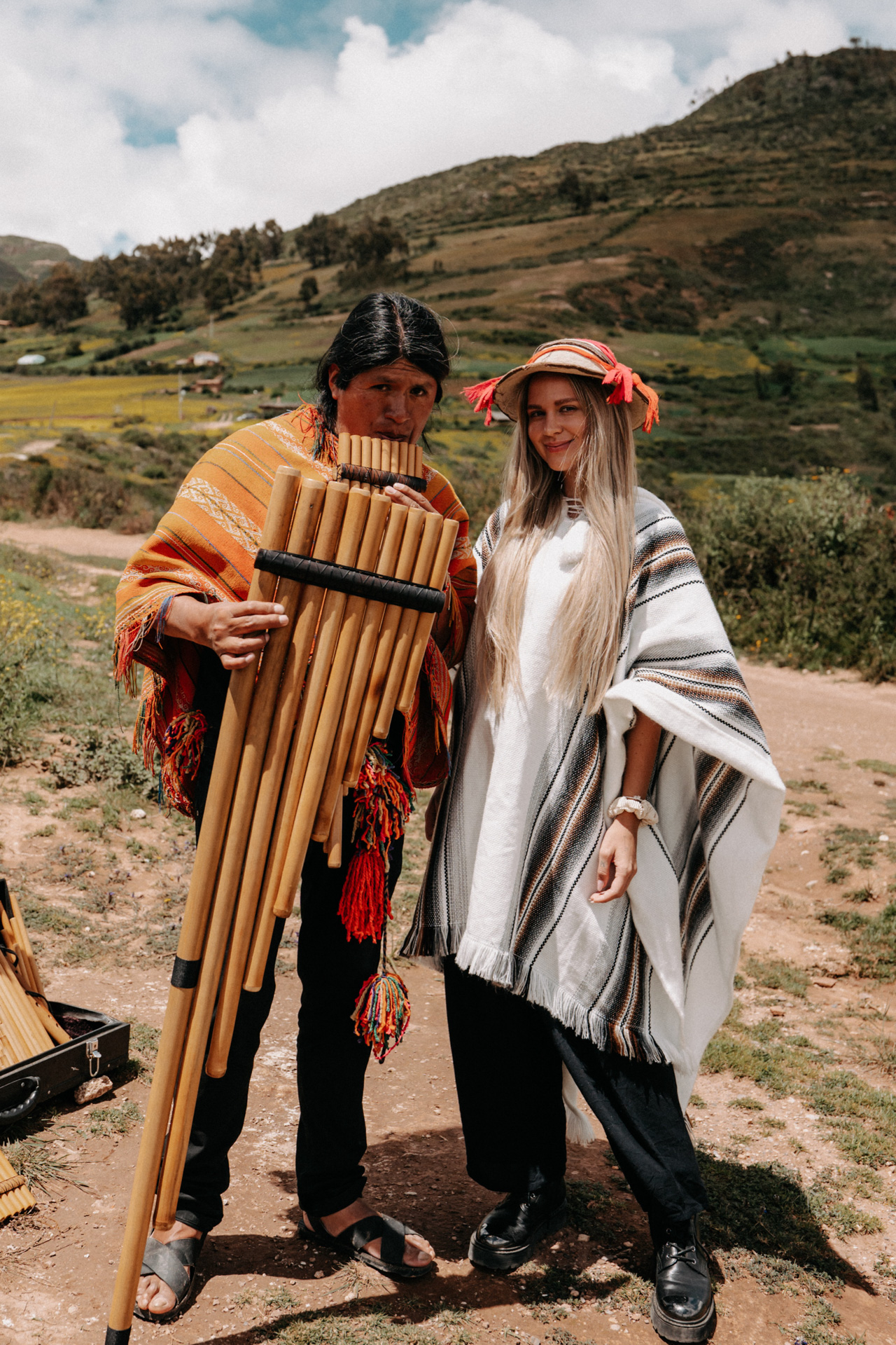 Woman with local musician playing pan flute in traditional dress in Chinchero, Peru