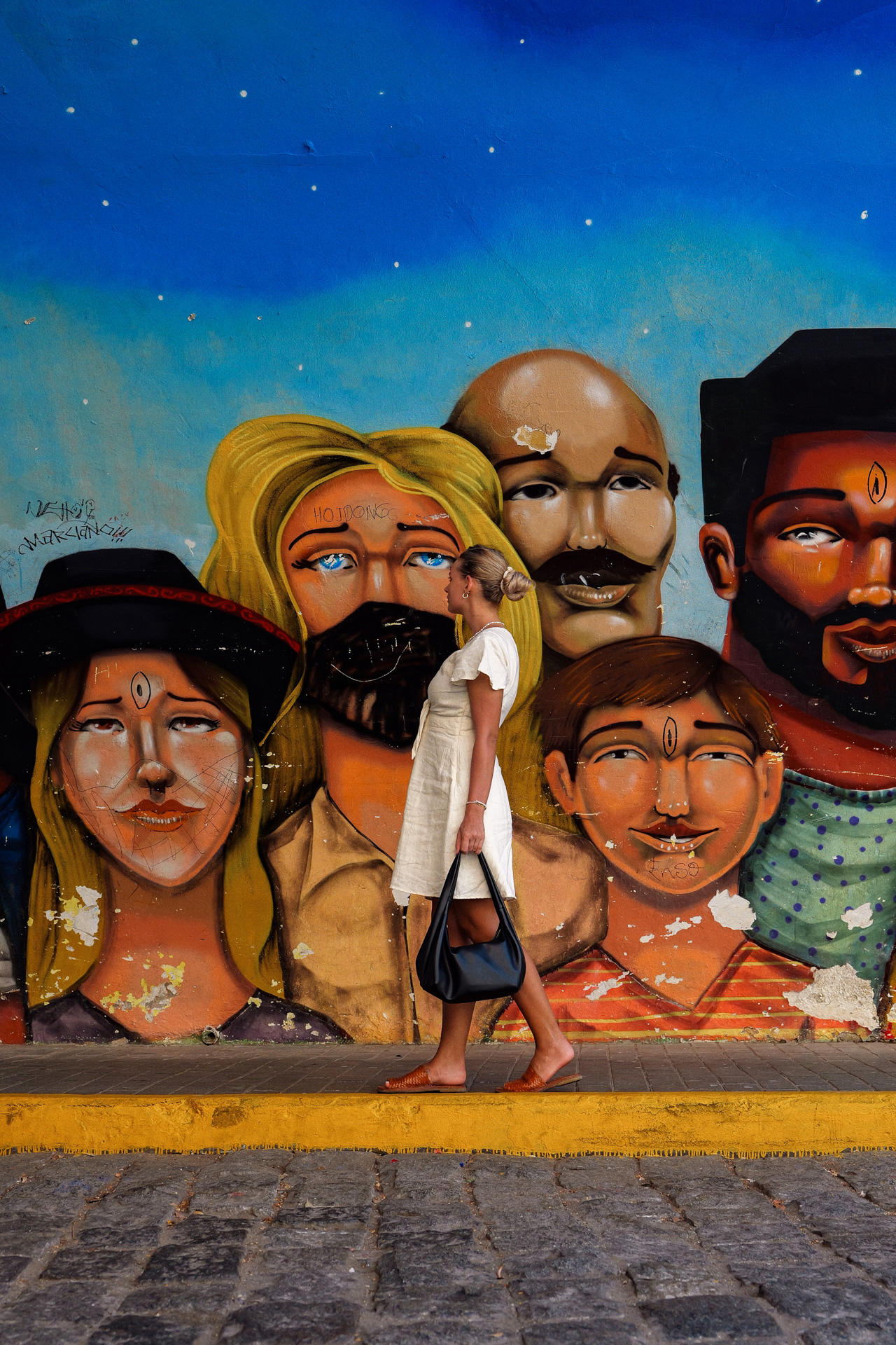 Woman walking past colorful street art mural in Barranco, Lima, Peru