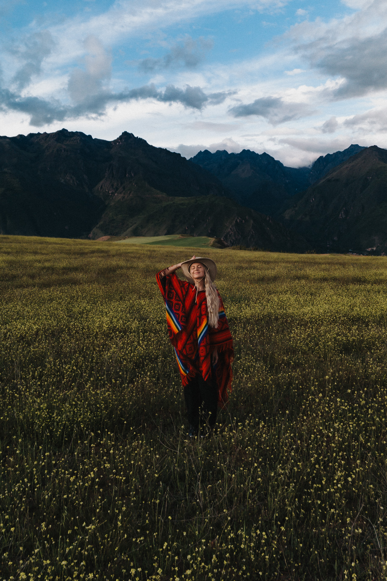 Woman standing in front of dramatic mountains in the Sacred Valley, Peru