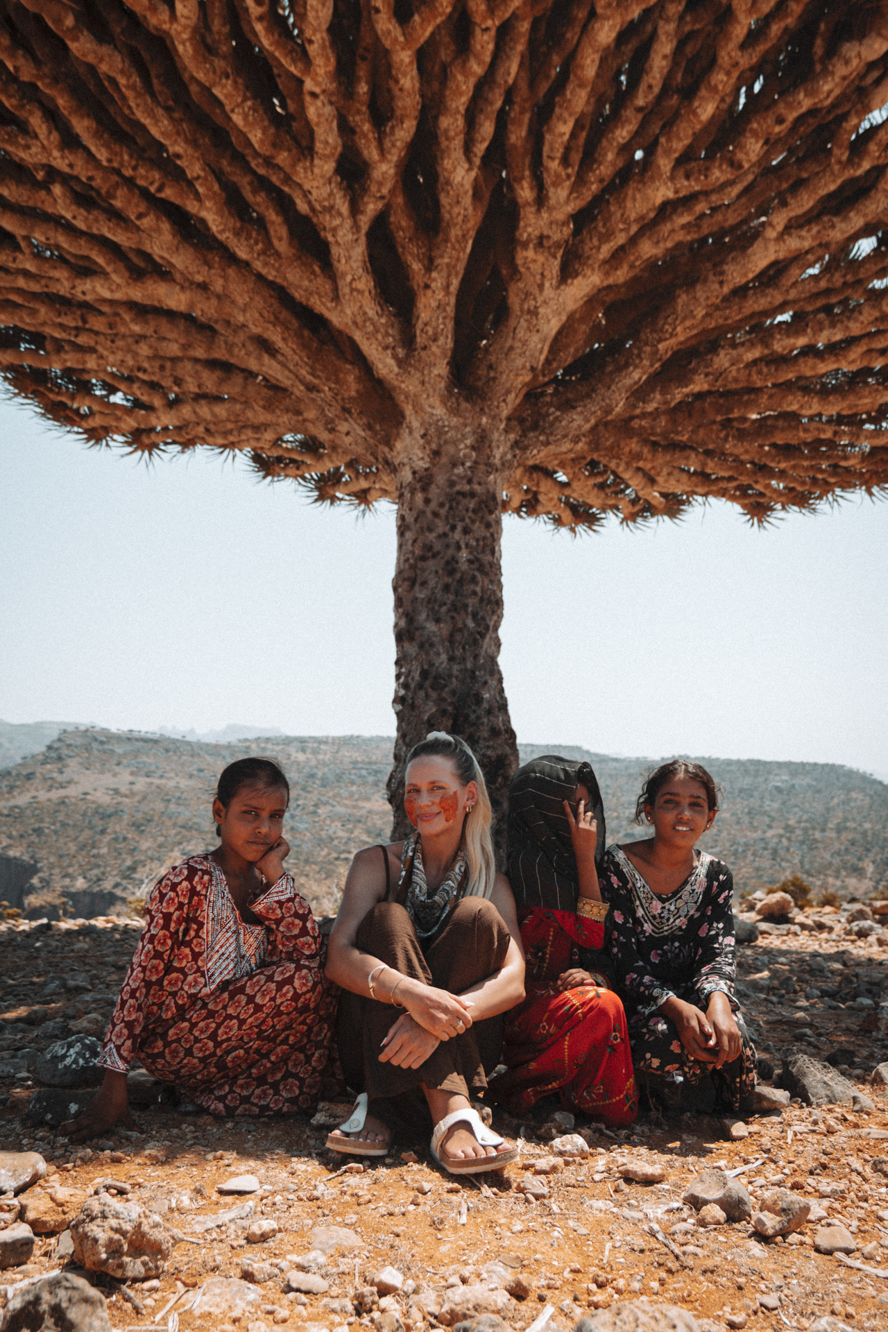 A group of women sitting together under a Dragon Blood Tree of Socotra Island.