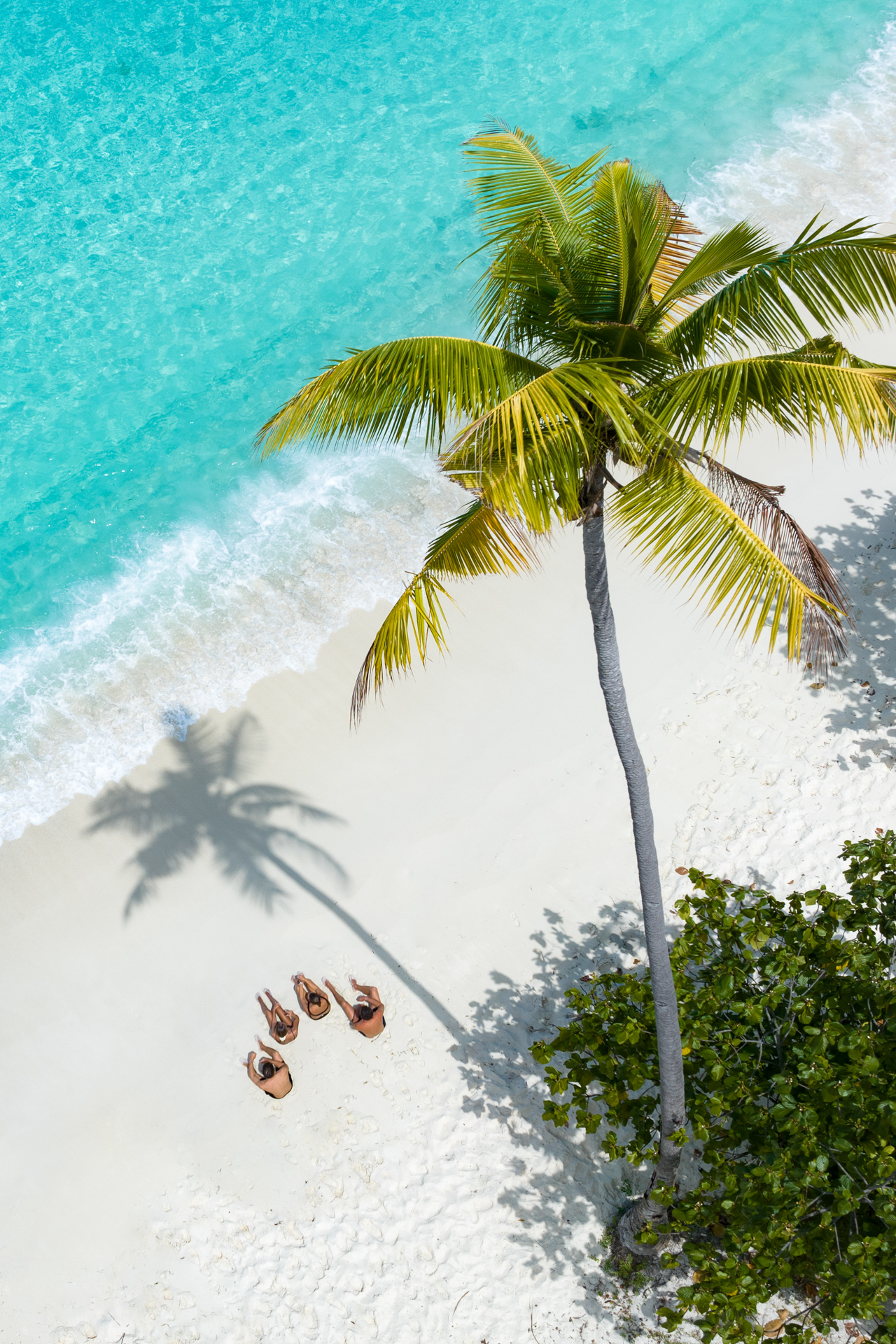 People sitting on the Banggai Laut beach on the Banggai Islands in Sulawesi
