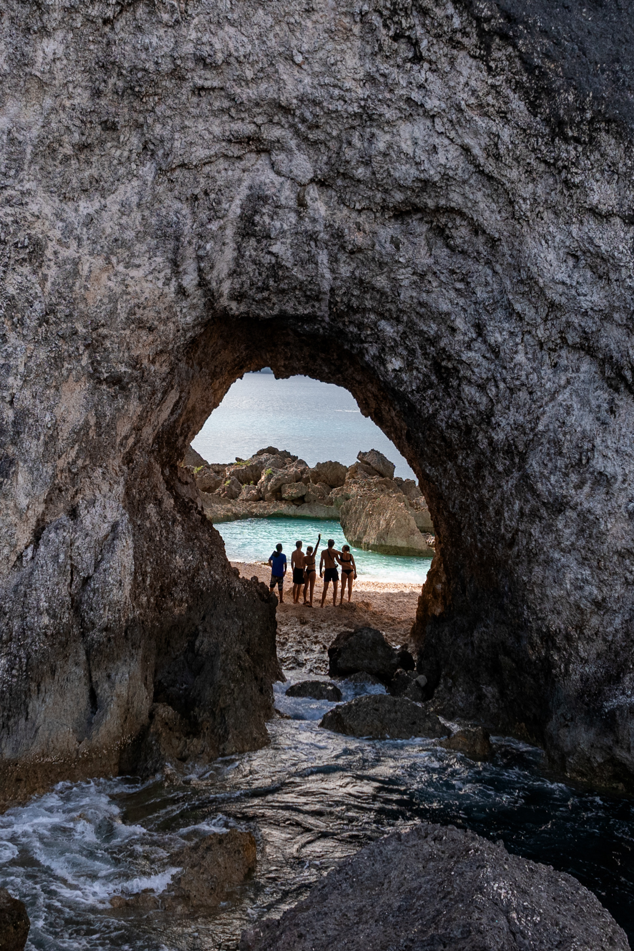 People standing in front of a Cave on Banggai Islands