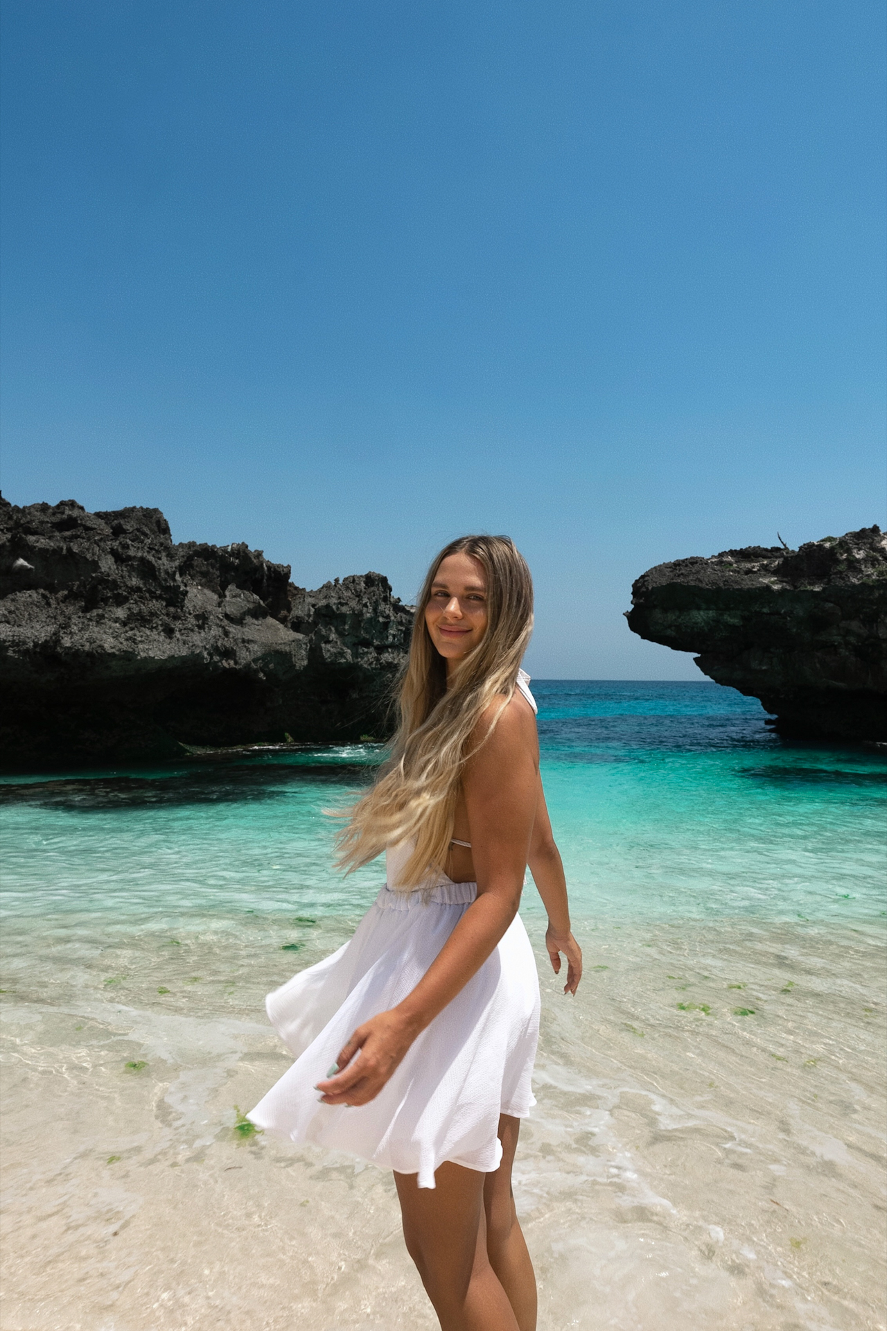 Woman walking in turquoise water at Mandorak Beach, Sumba Island