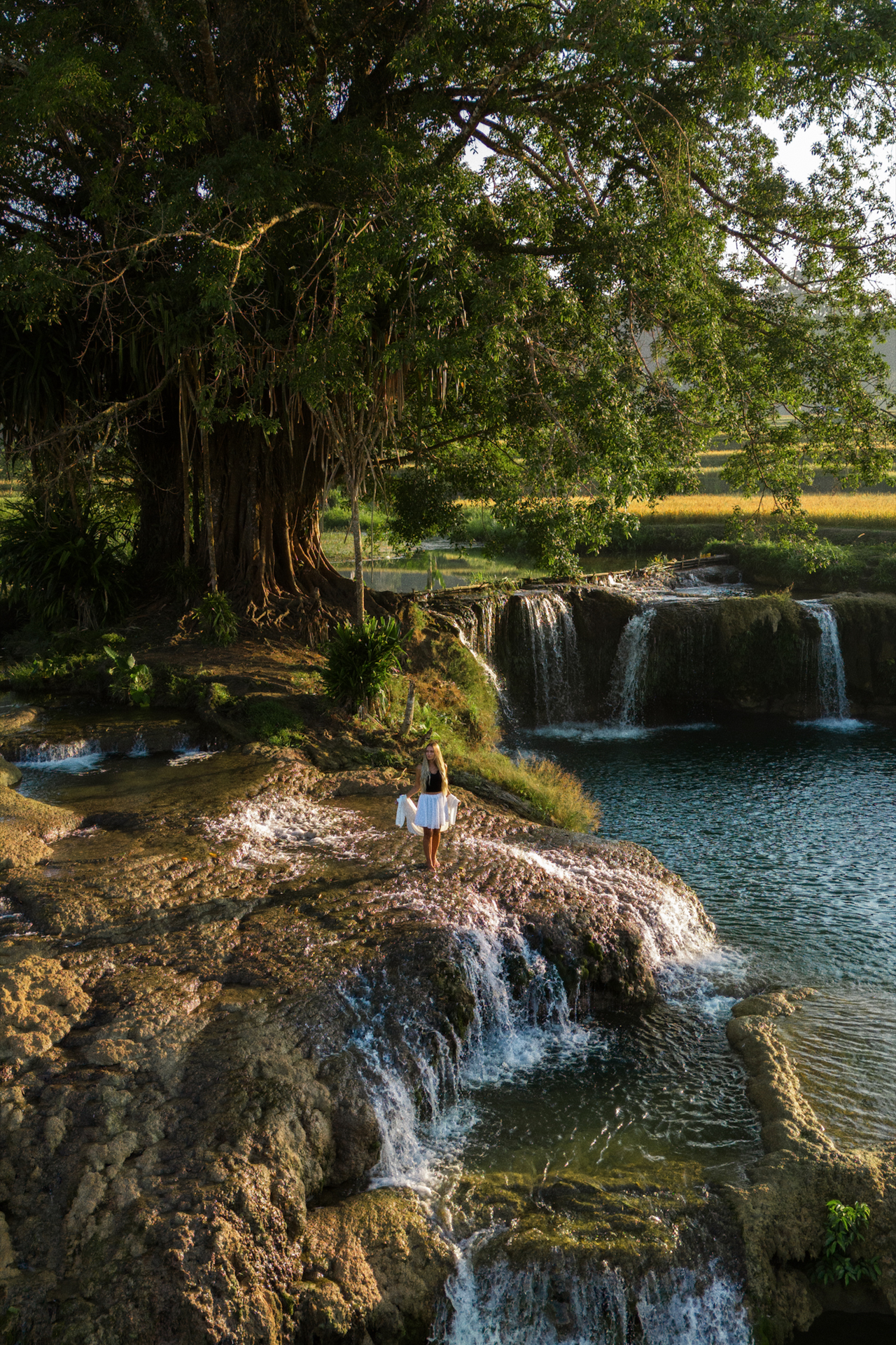Woman standing on Weekacura waterfalls on Sumba