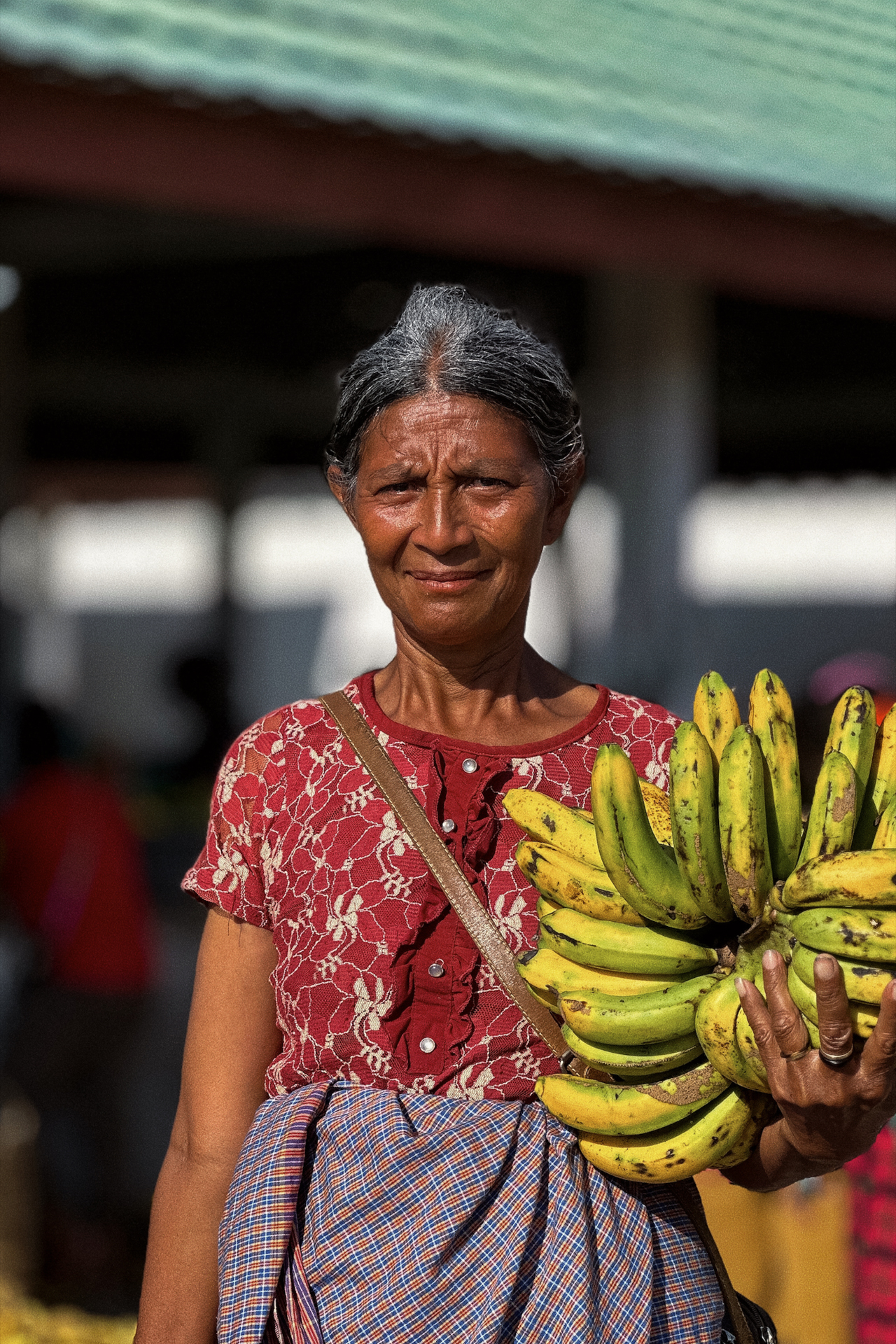 Local vendor holding bananas at Waikabubak market, Sumba Island