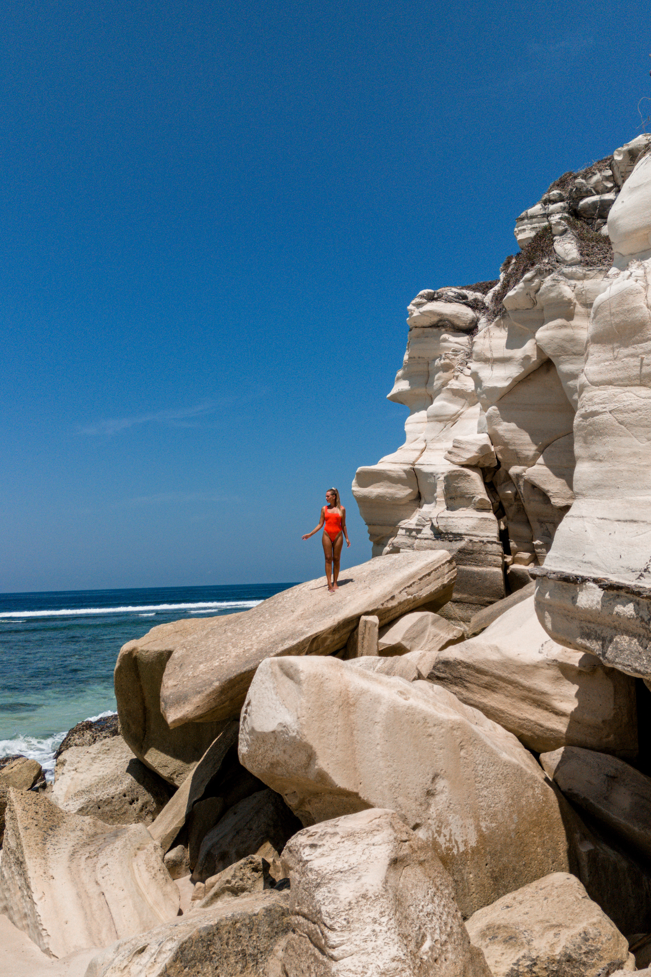 Woman standing on rocks at Watu Bela Beach, Sumba Island