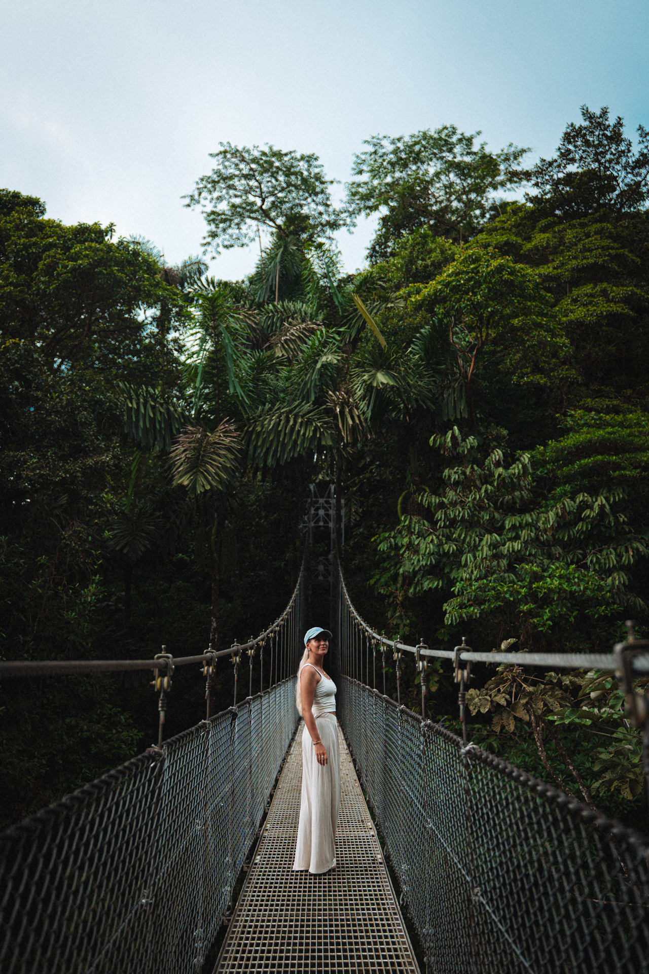 Woman standing on a hanging bridge in the rainforest in La Fortuna Costa Rica