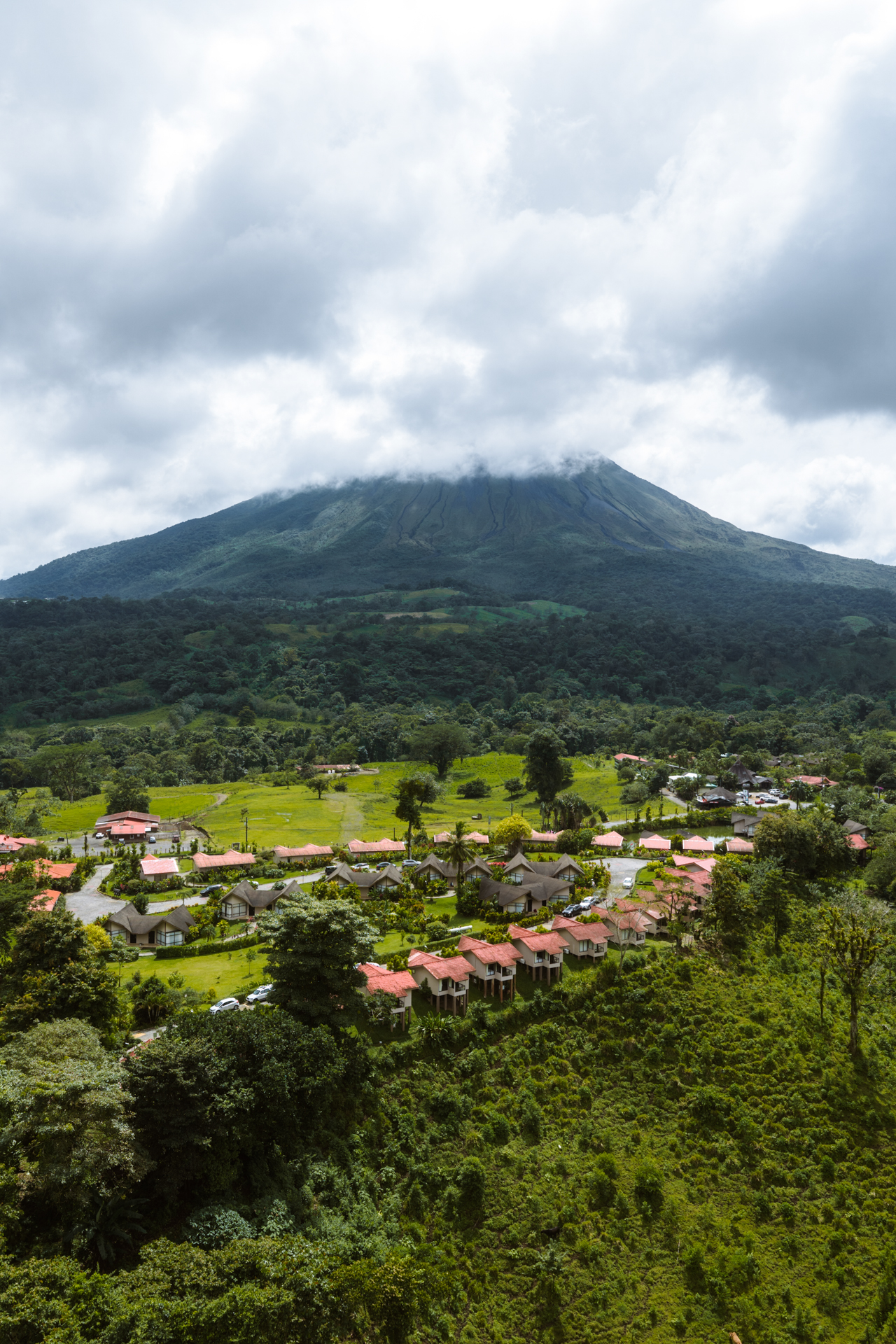 Arenal Volcano rising above La Fortuna town and green landscape in Costa Rica