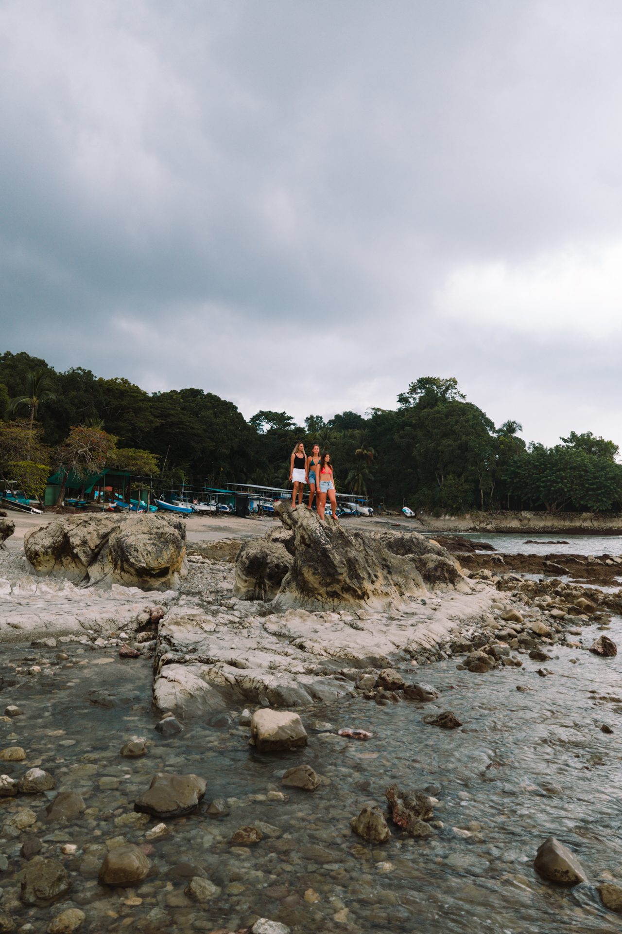 Mal País tide pools Costa Rica with rocky coastline and people standing on natural rock formations