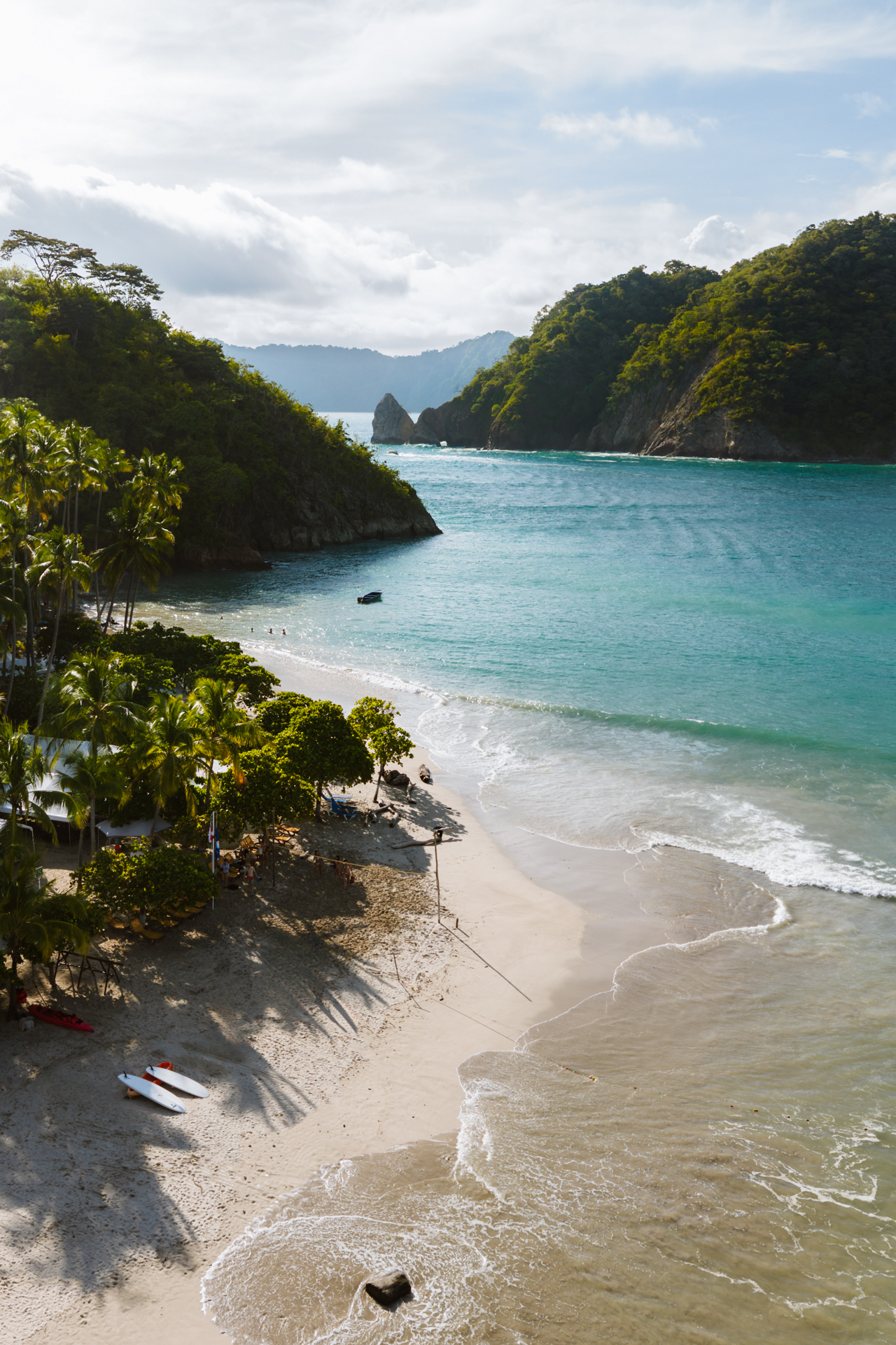 Tortuga Island beach in Costa Rica with turquoise water, palm trees, and lush green cliffs