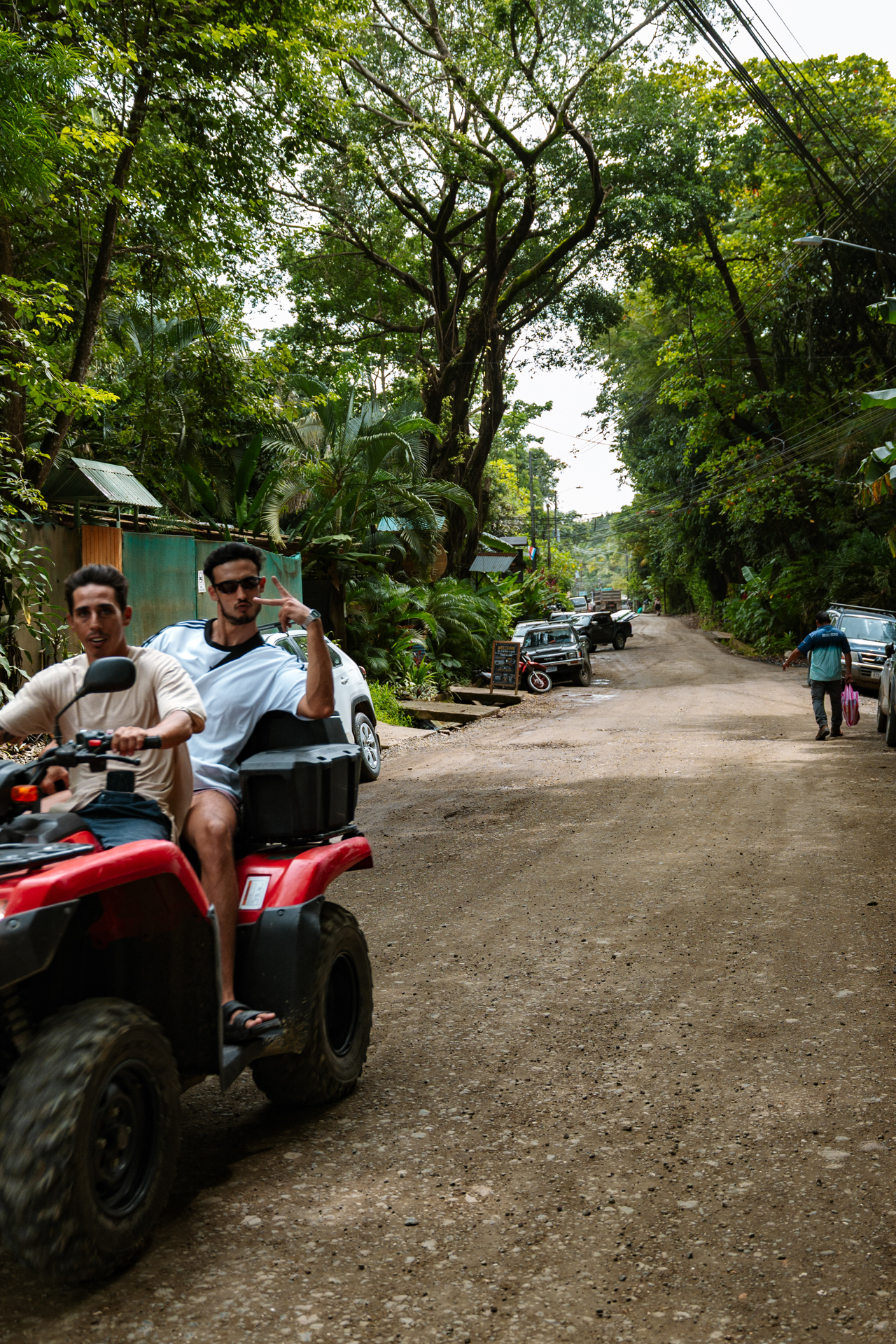 Men riding ATV on jungle road in Costa Rica surrounded by tropical forest