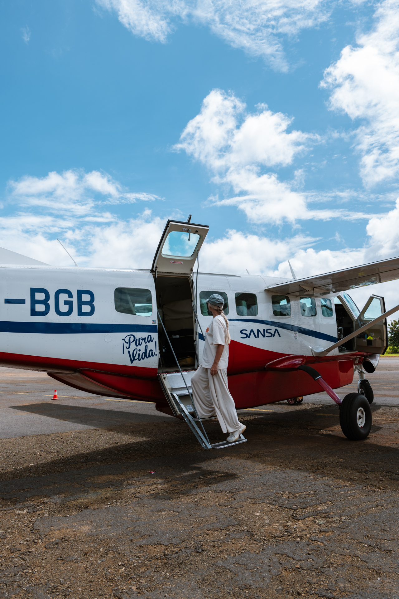 Woman boarding a small SANSA plane in Costa Rica for a domestic flight
