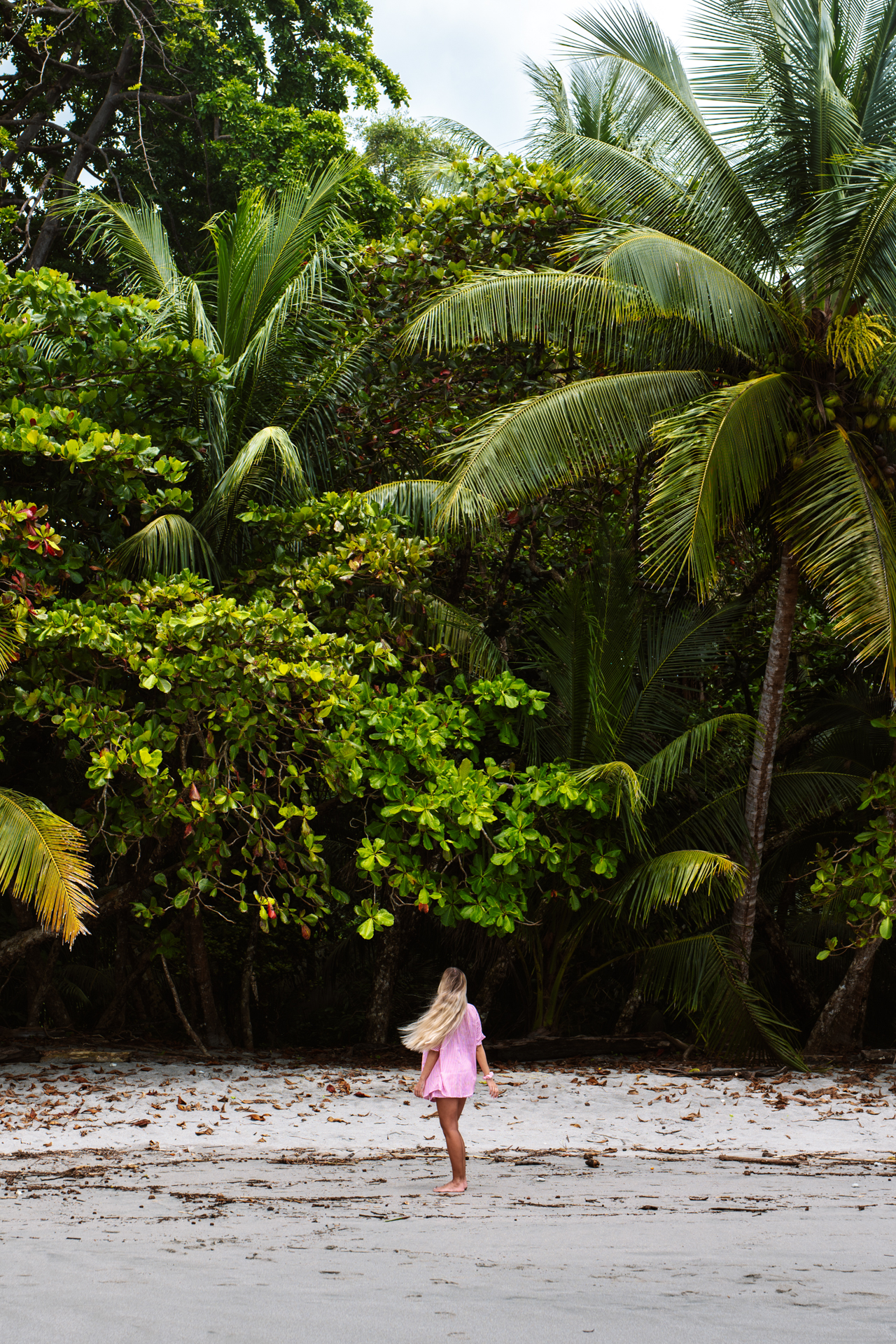 Woman walking on a tropical beach with palm trees in Manuel Antonio Costa Rica