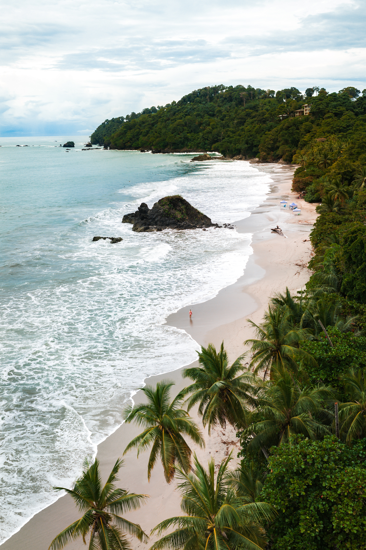 Aerial view of Manuel Antonio coastline in Costa Rica with palm trees and ocean waves