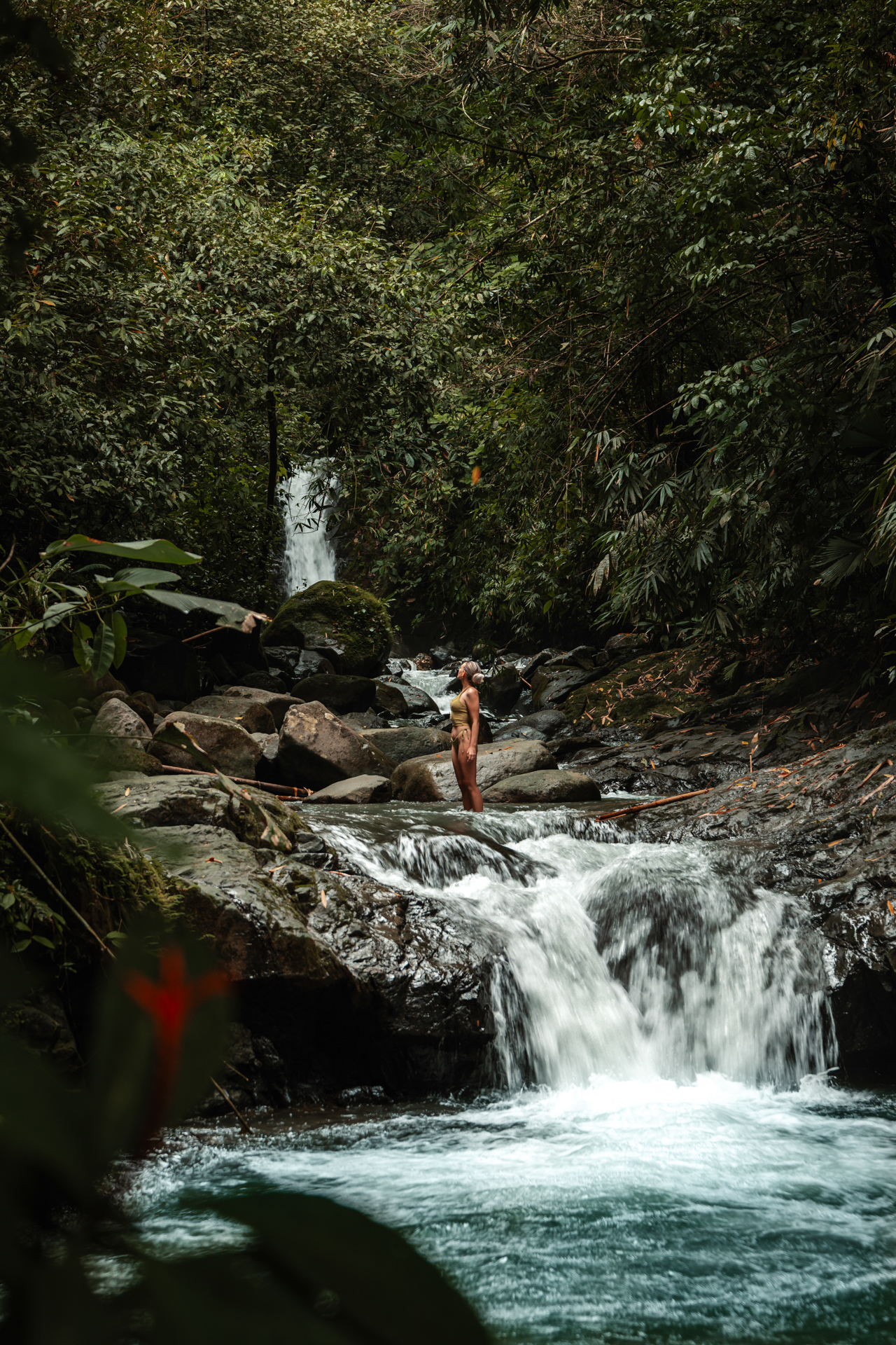 Woman standing in a jungle river with small waterfall in Uvita Costa Rica