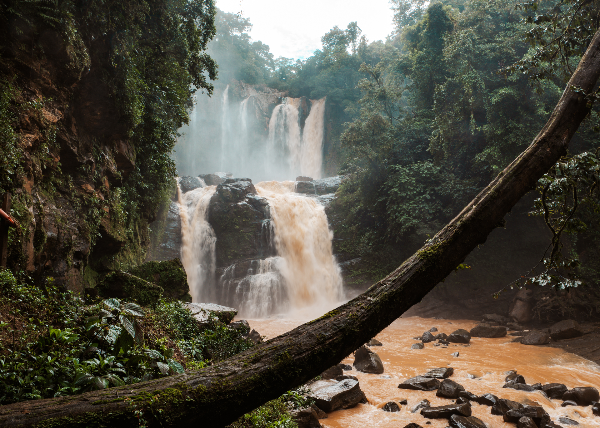 Nauyaca Waterfalls in Costa Rica surrounded by lush rainforest with powerful cascading tiers and rocky river below