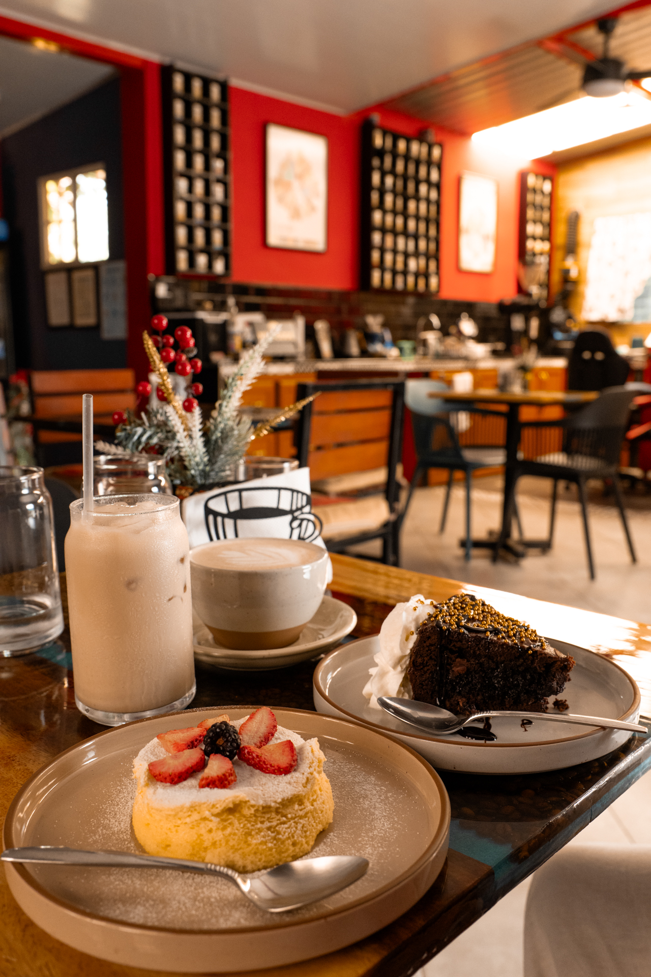 Coffee, iced drink, and cakes served on a table inside a cozy café on Ruta de las Flores
